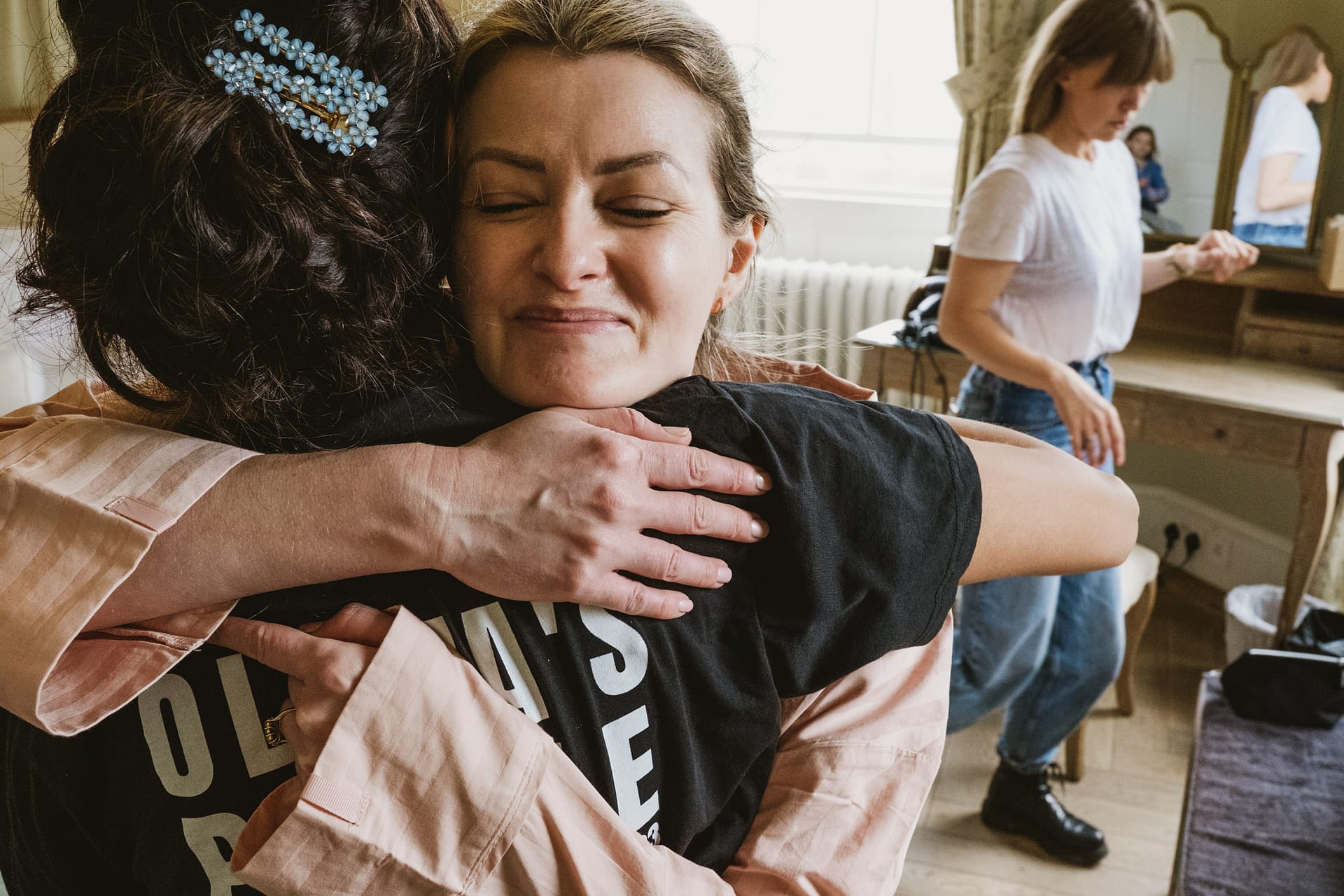 Women hugging warmly in a cosy room.