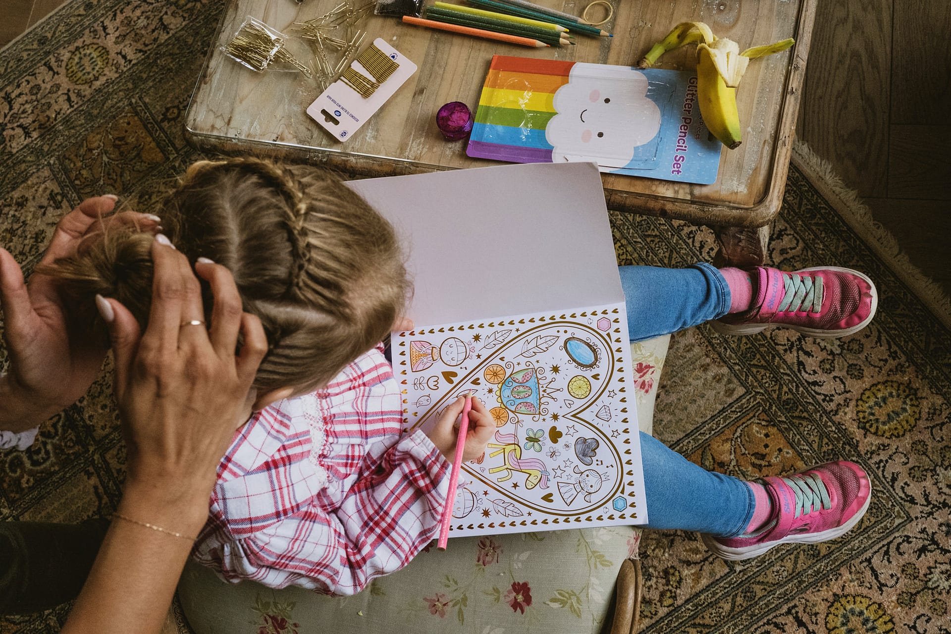 Child colouring book while having hair styled