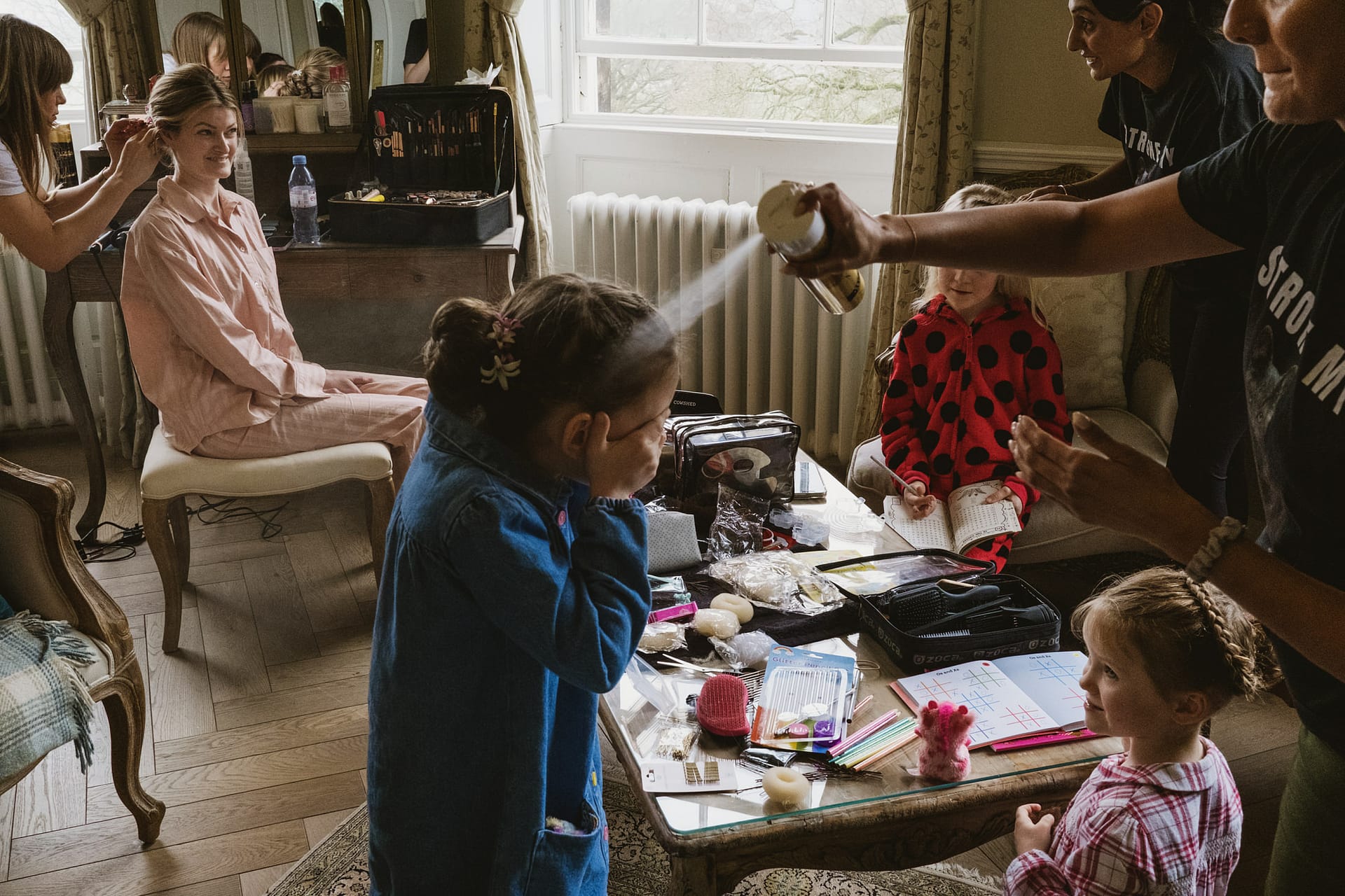 Woman getting ready surrounded by children and activities.