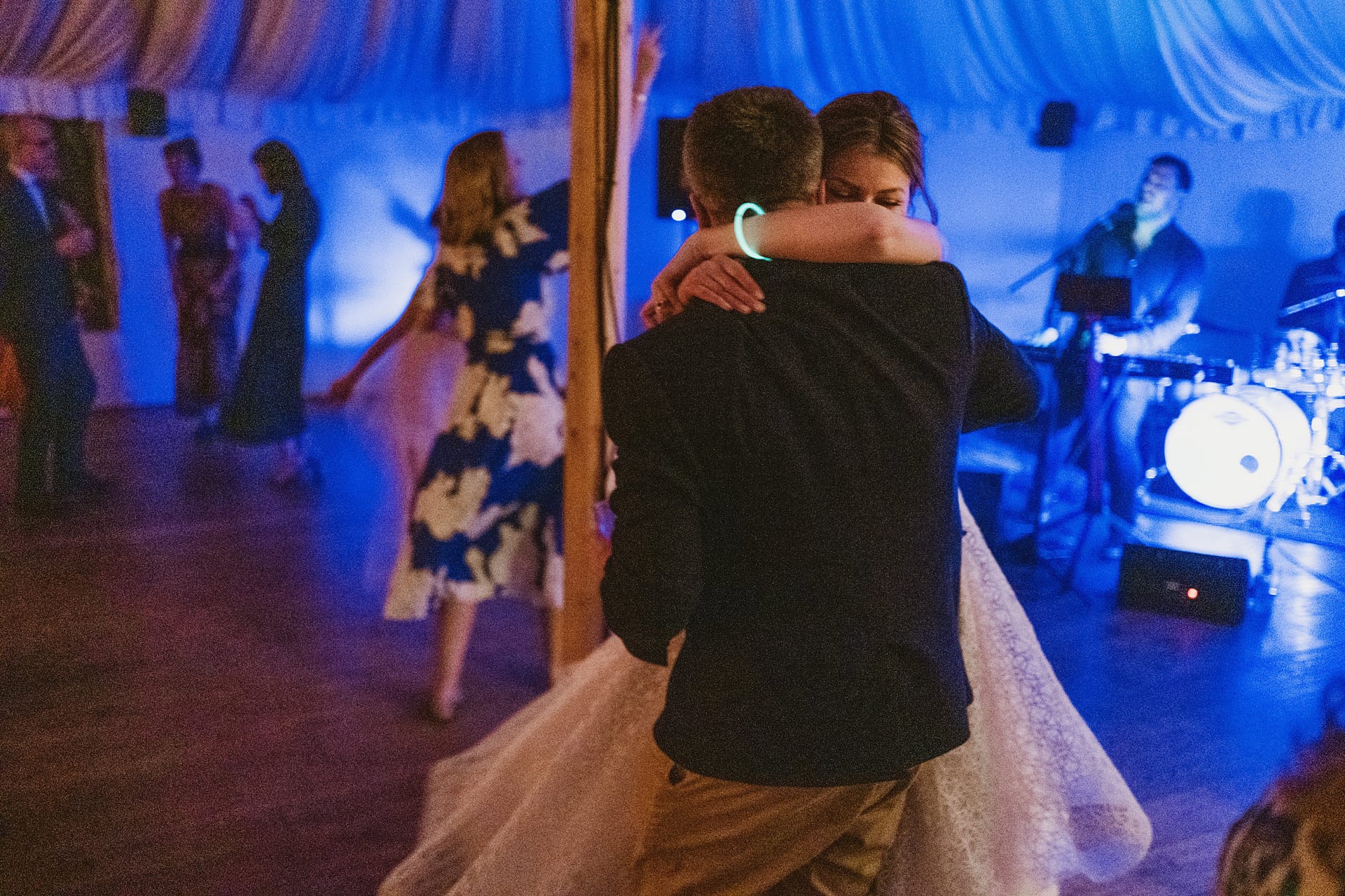 Couple dancing at wedding reception, live band playing.
