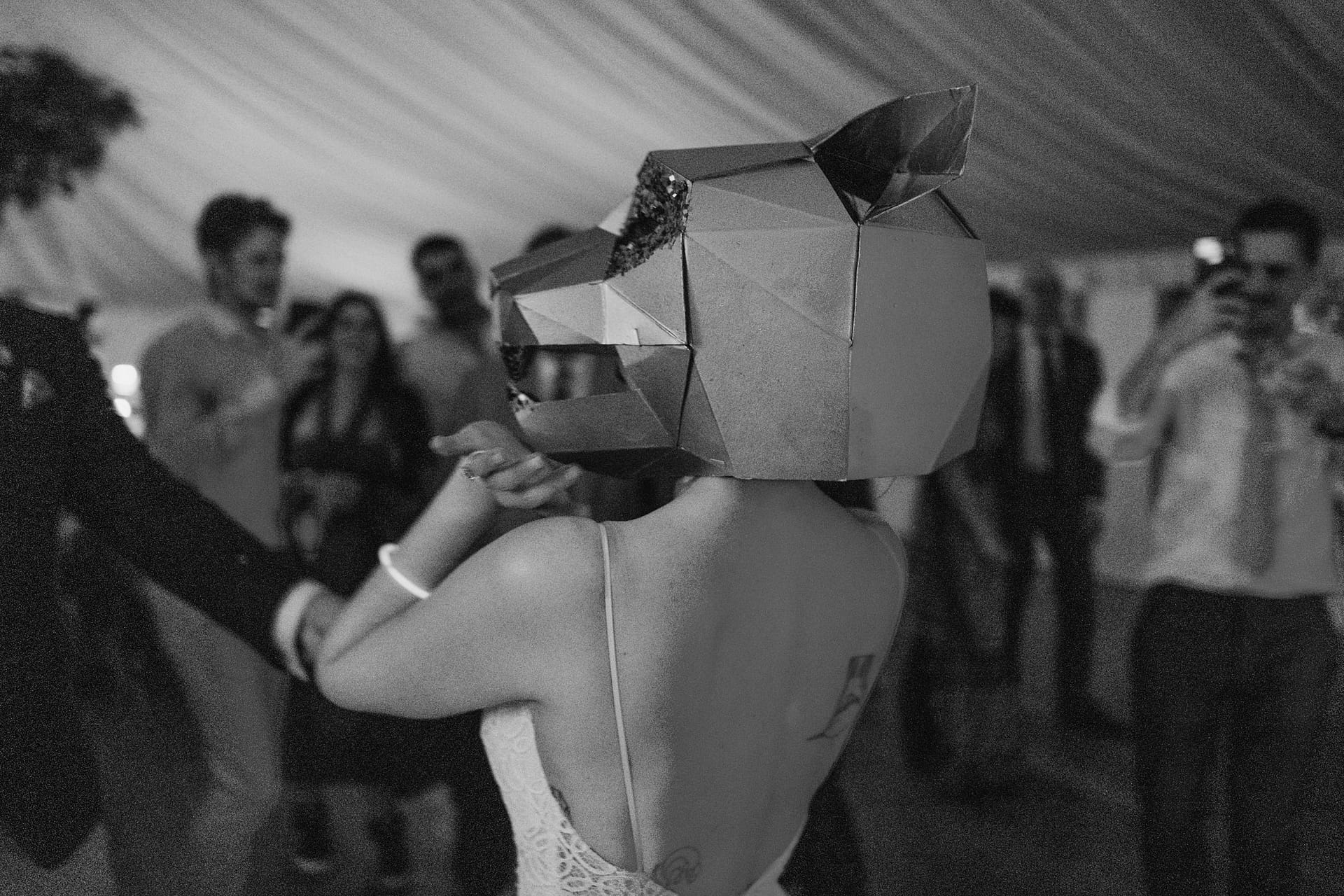 Person dancing wearing geometric animal mask at party