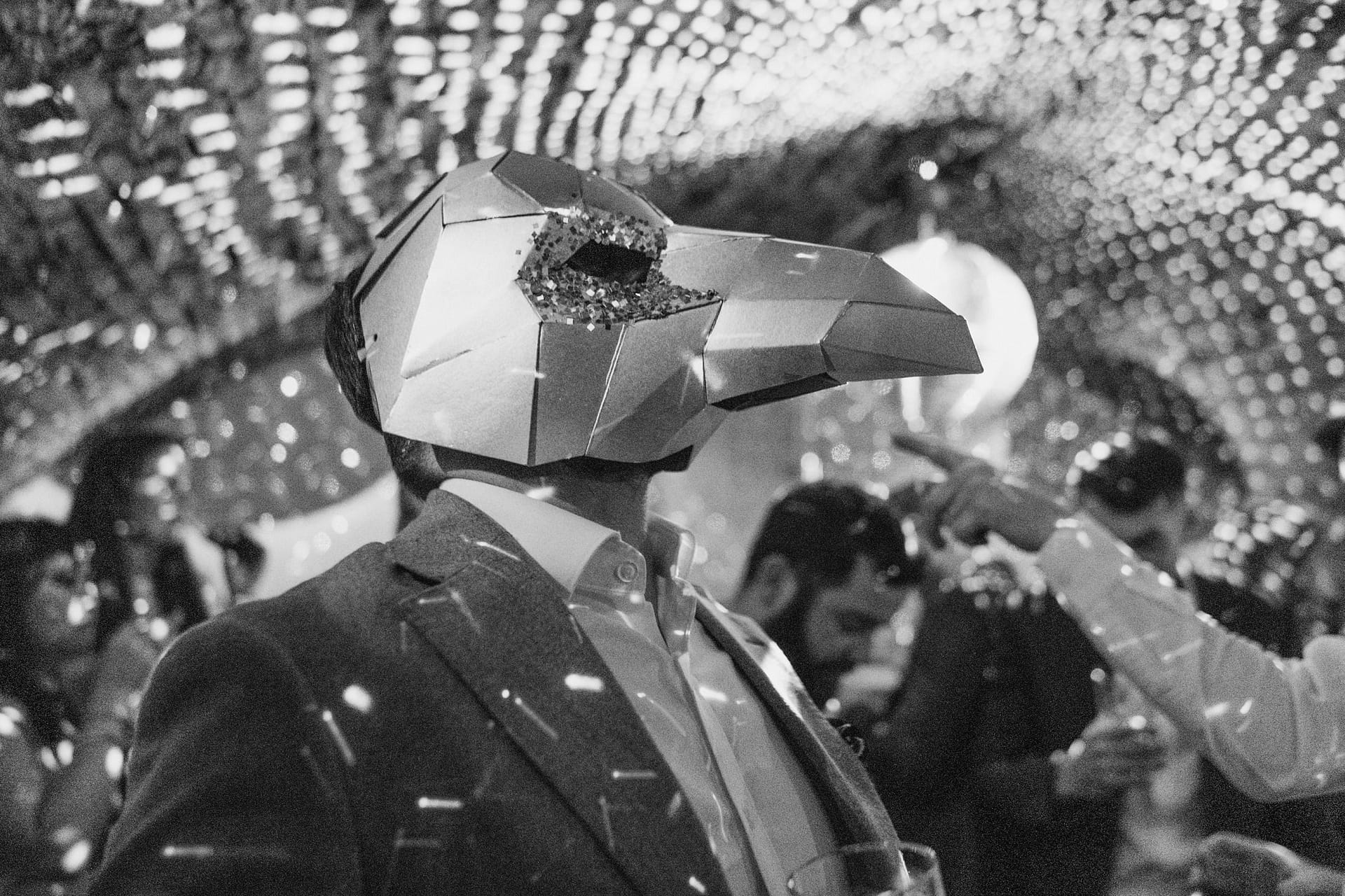 Masked party attendee under disco lights