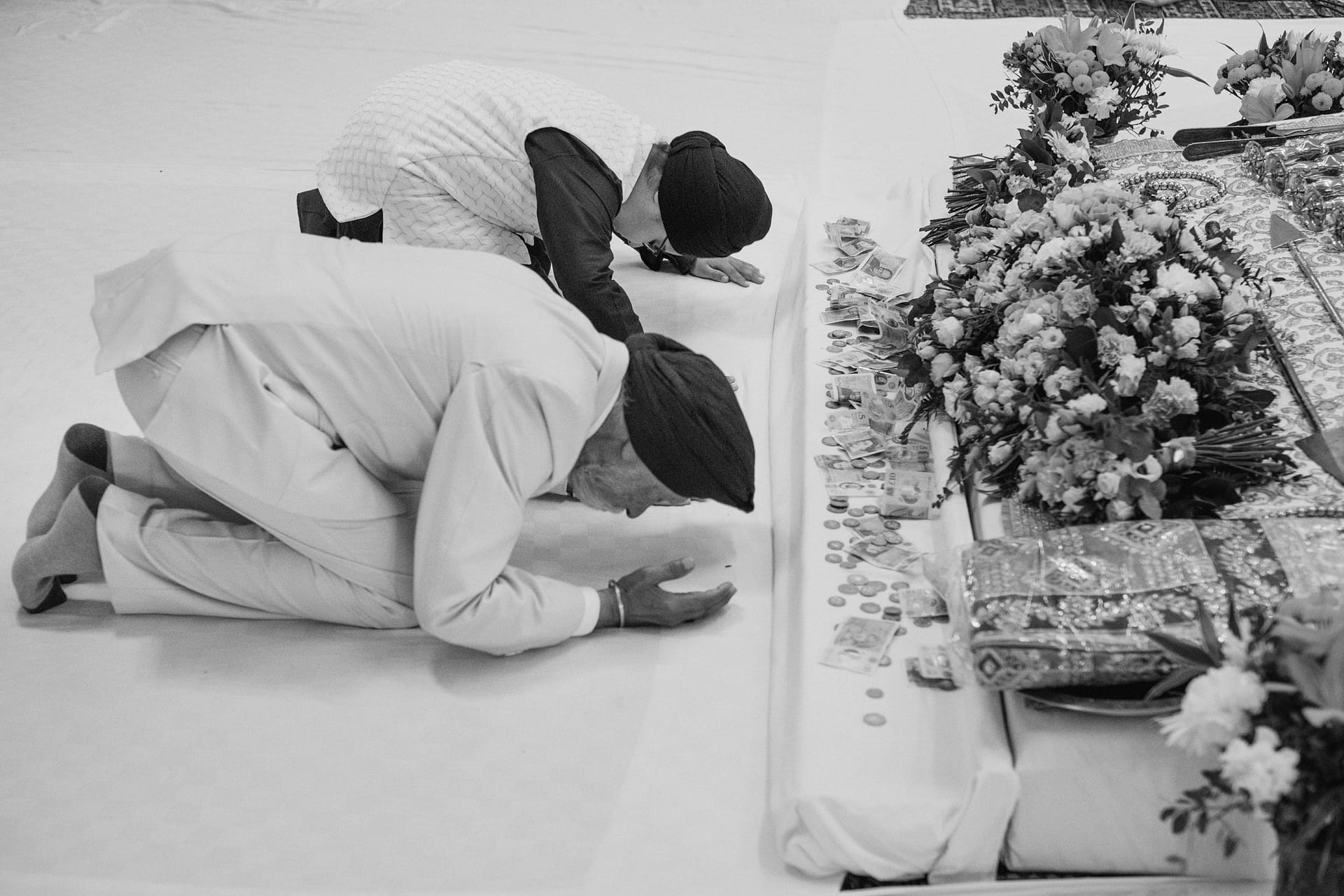 Two people bowing in a place of worship.