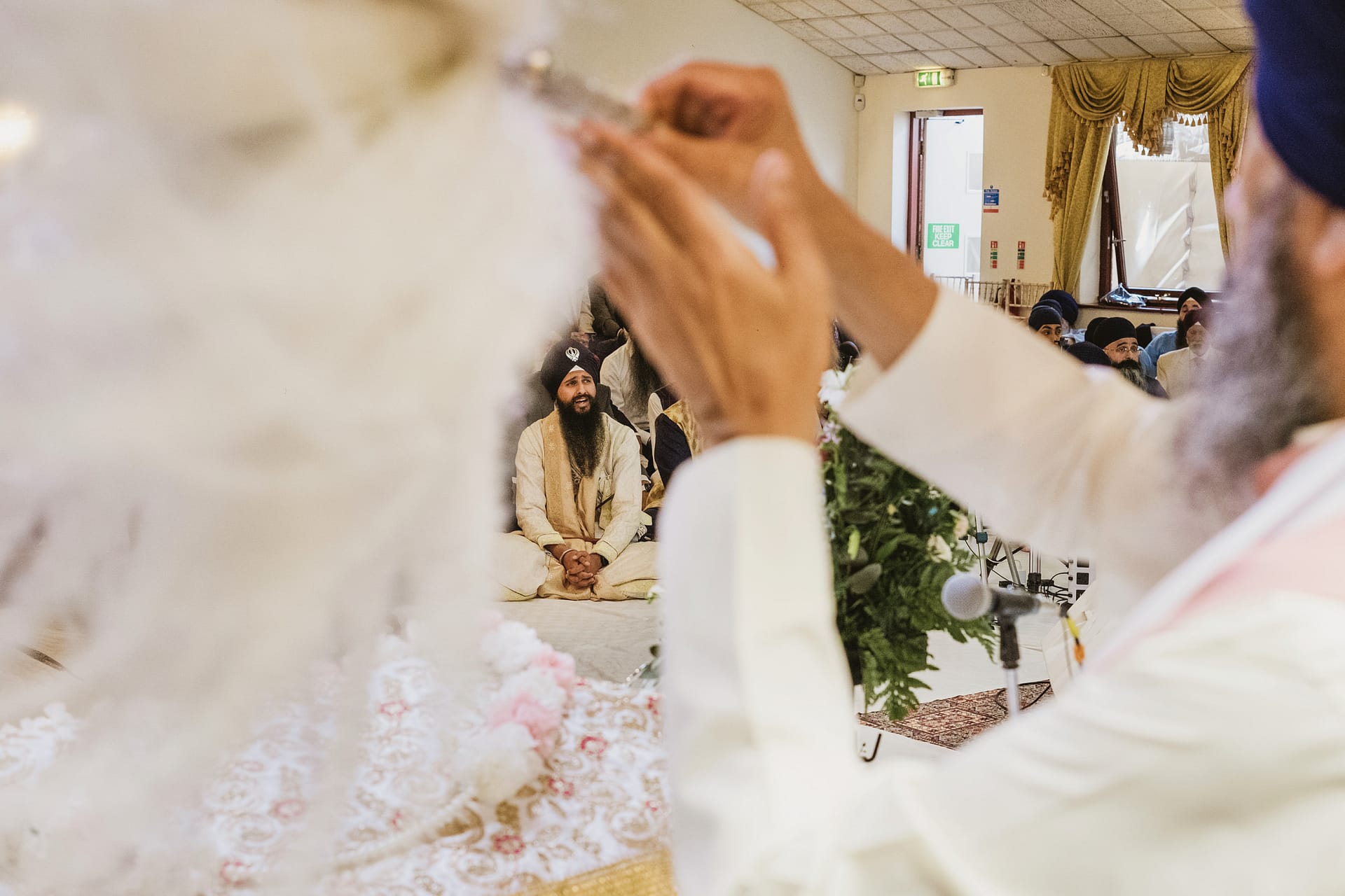 Sikh ceremony with people and religious items present.