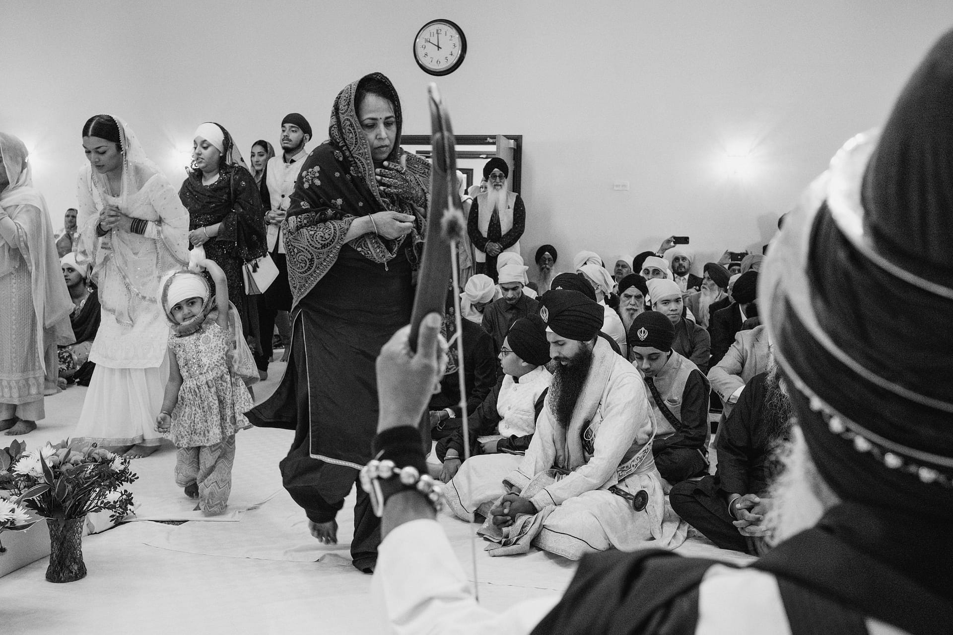 Sikh worshippers gathered in prayer at Gurdwara ceremony.