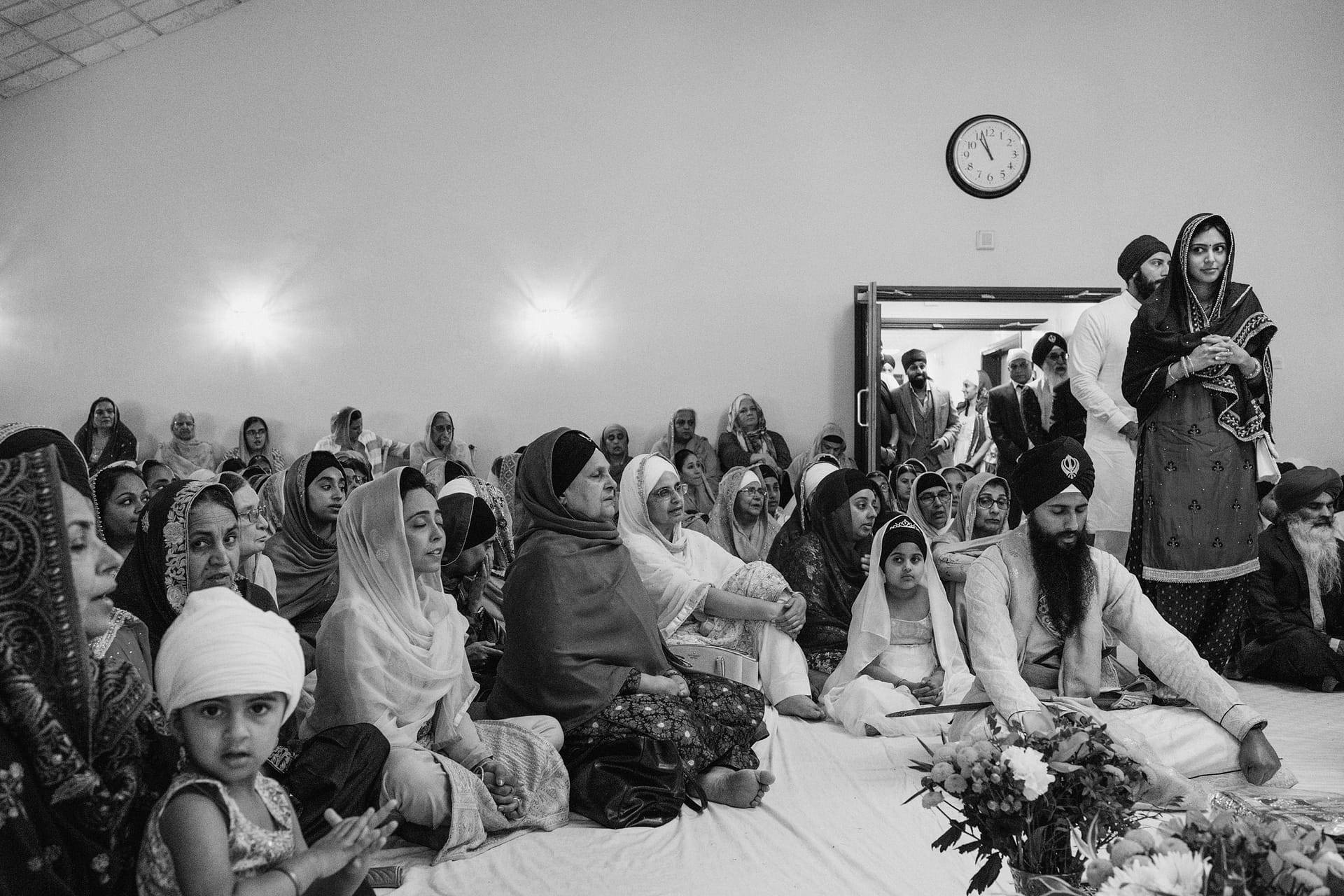 Sikh community gathers in prayer inside temple.