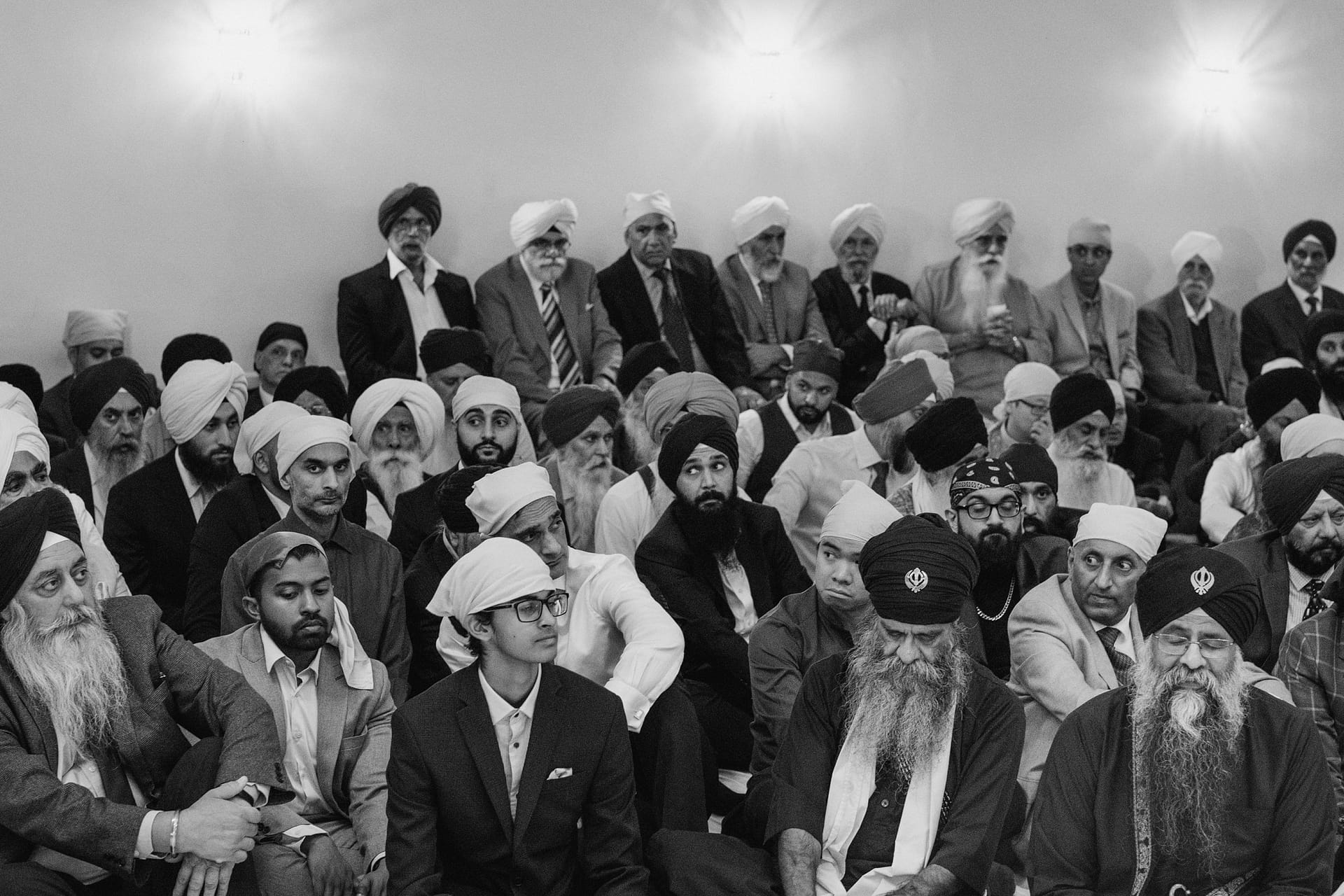 Large group gathers in traditional attire for ceremony.