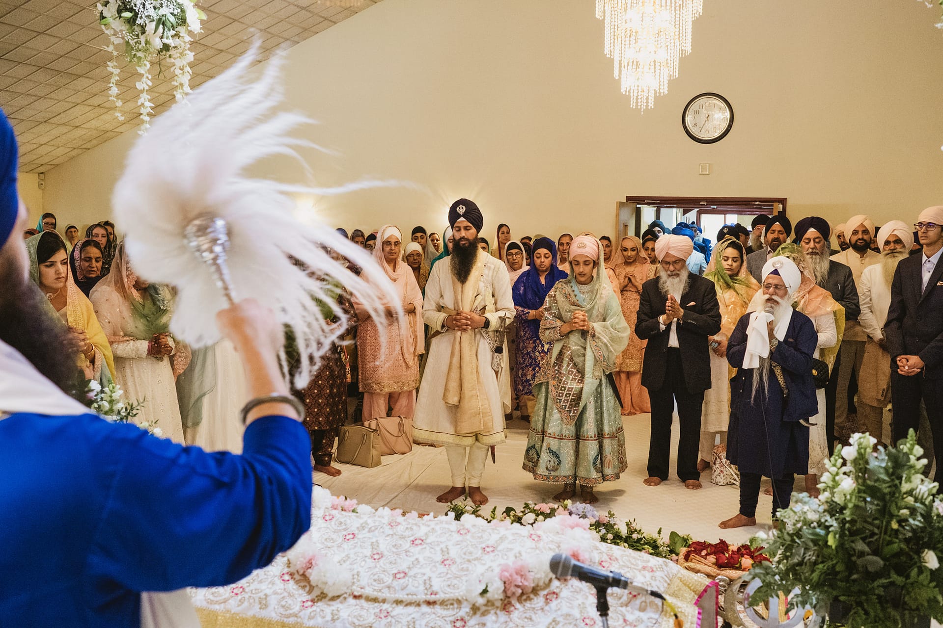 Sikh wedding ceremony with congregation in a gurdwara.