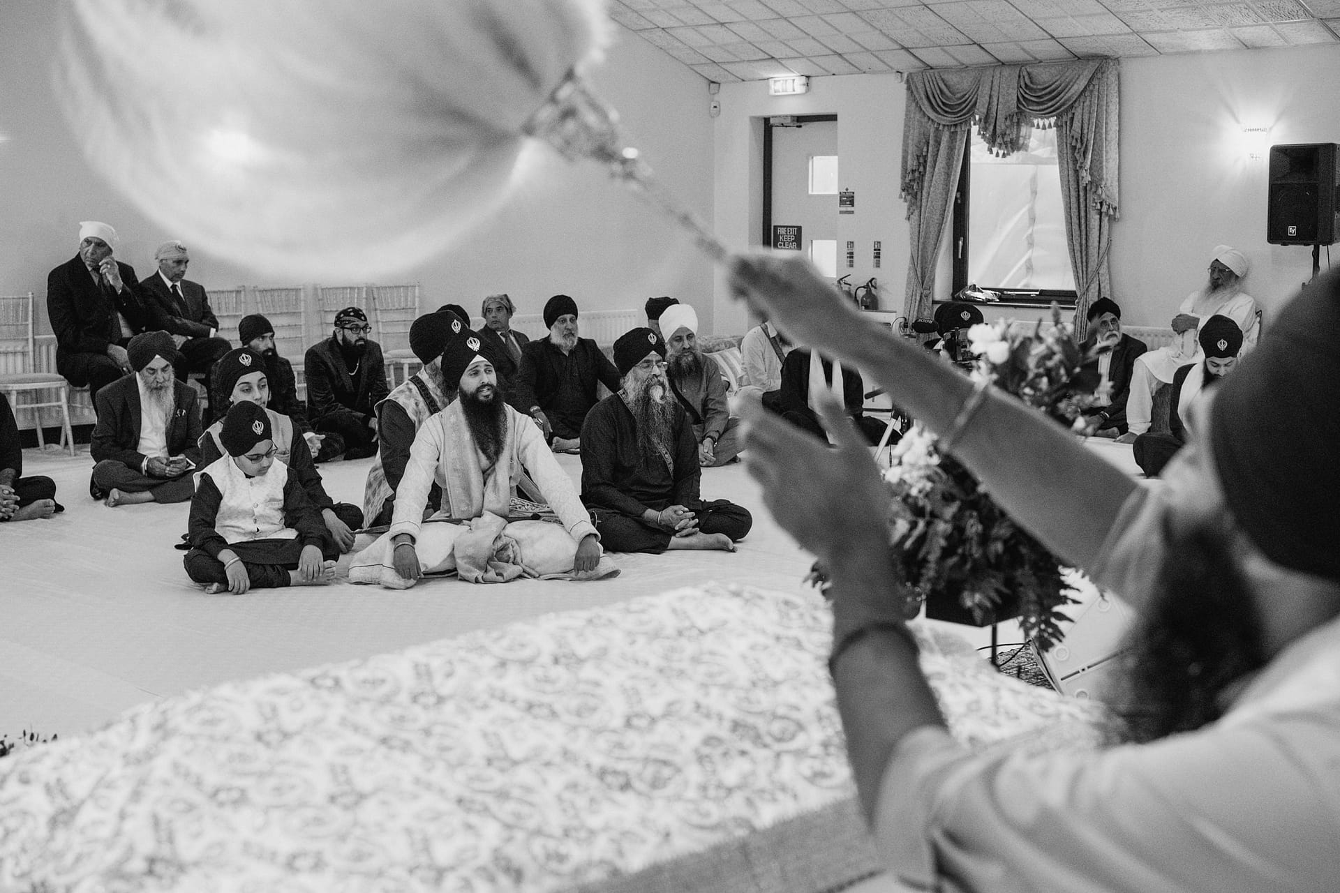 Sikh congregation sitting during religious ceremony.