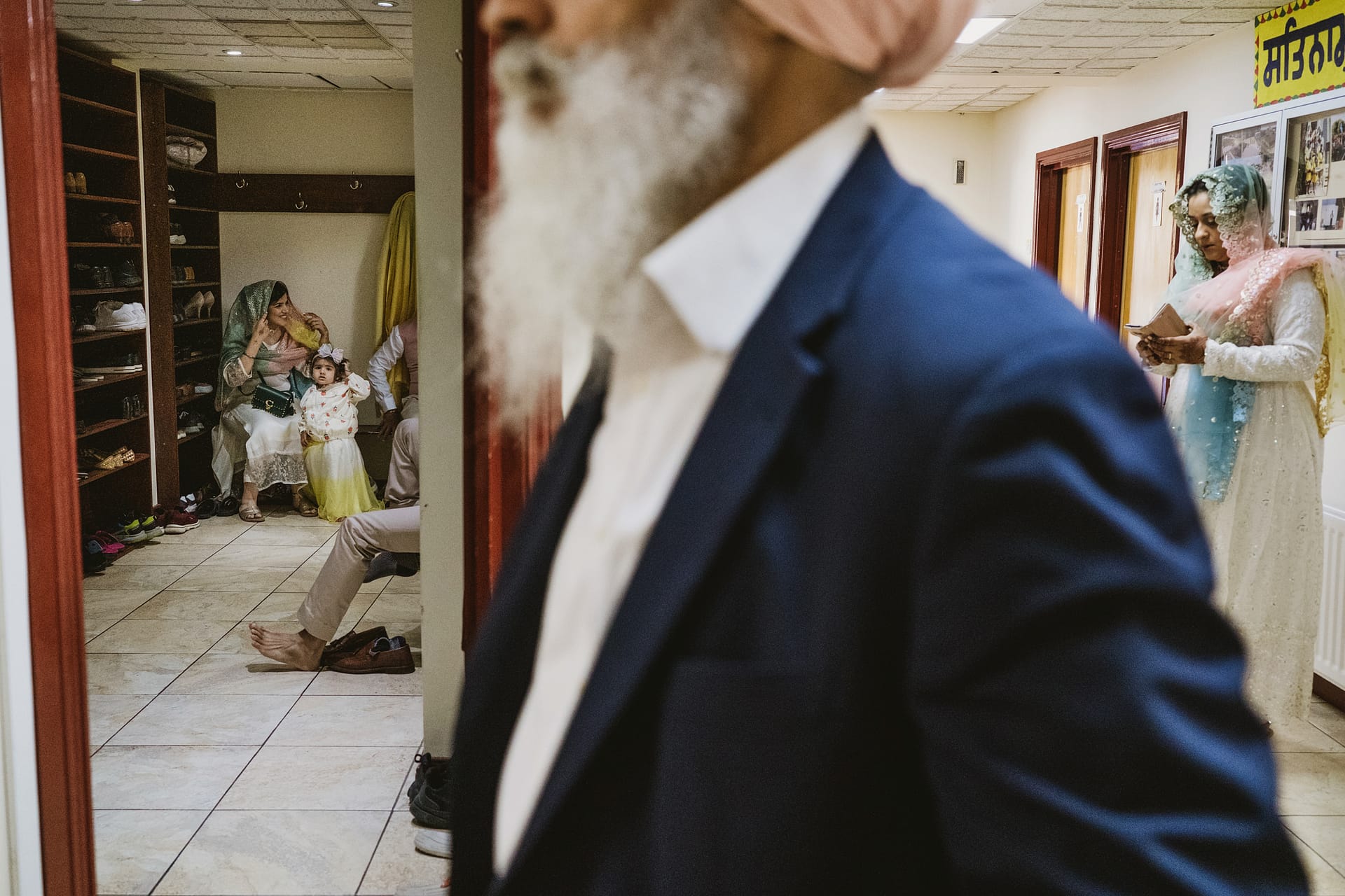 People gathering in a hallway, reading and chatting.