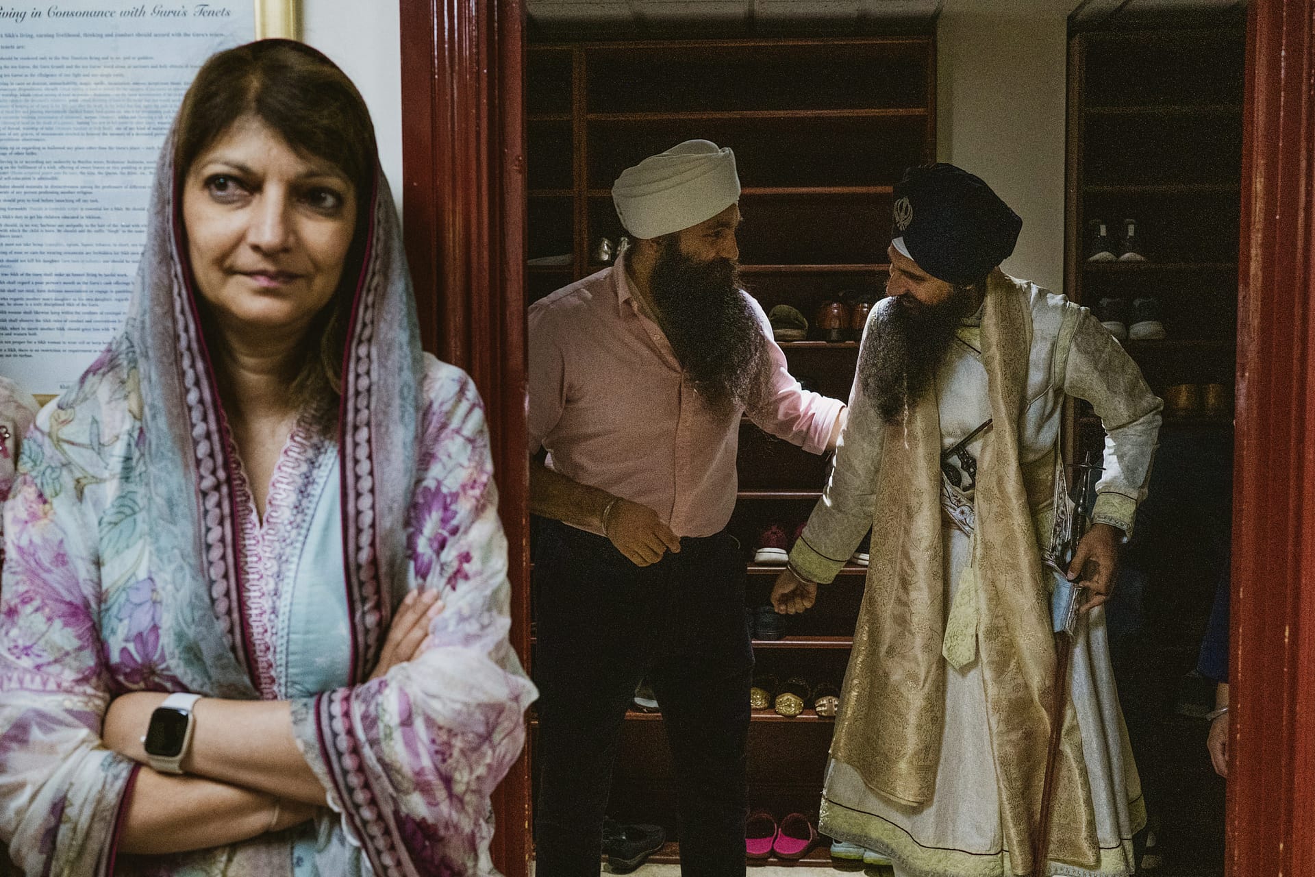 People in traditional attire outside shoe storage area.
