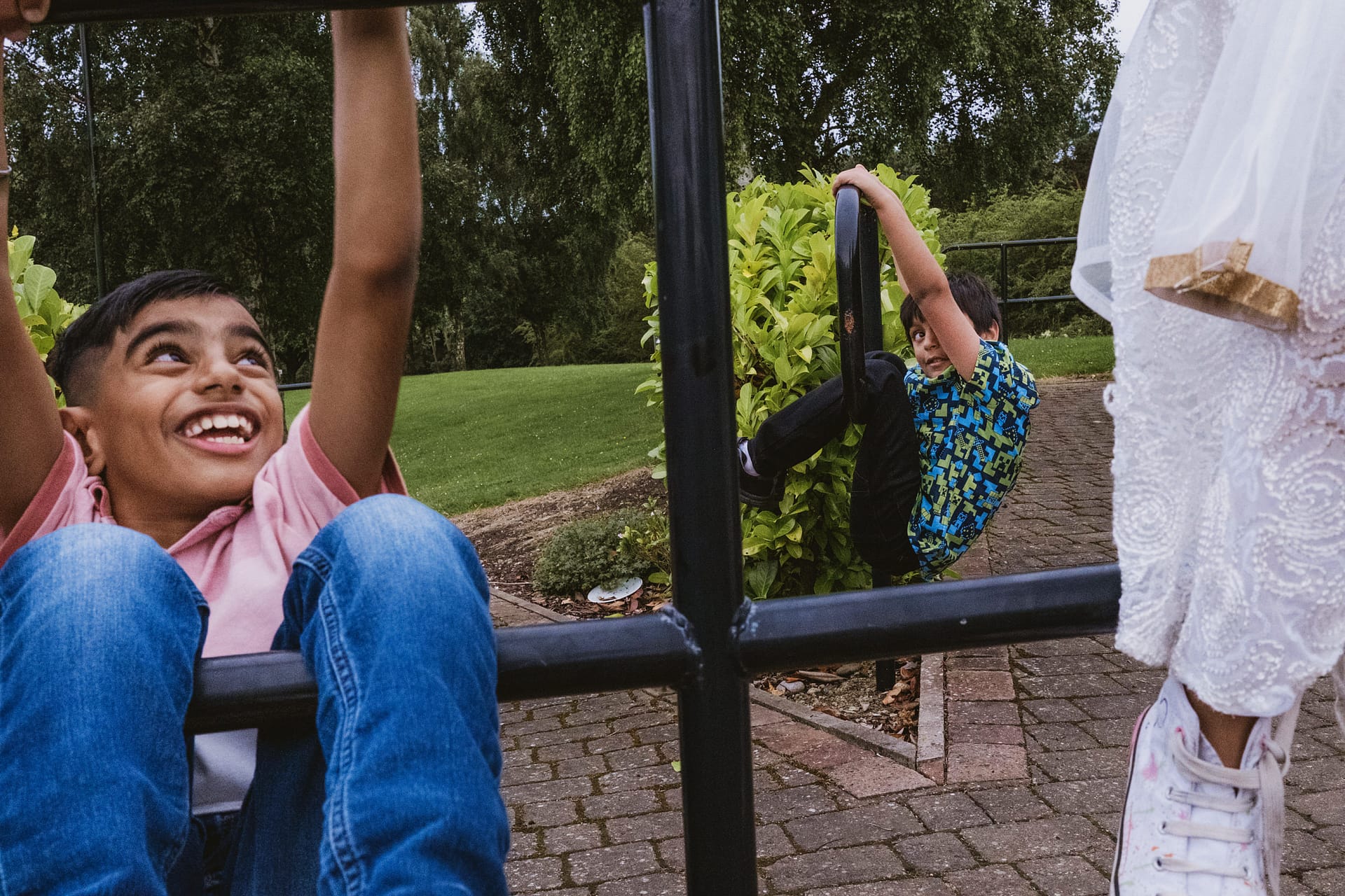 Children playing on a metal climbing frame outside.