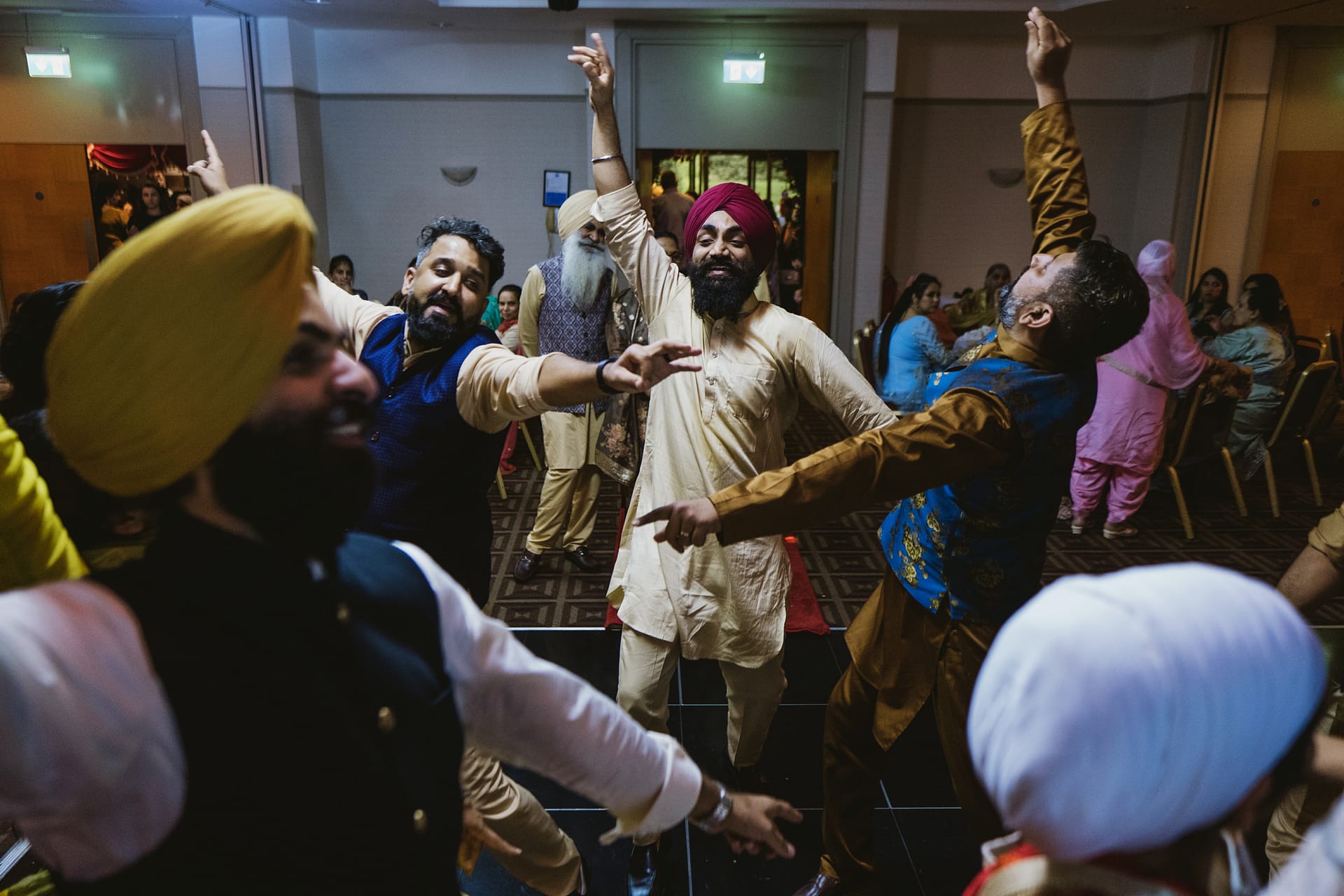 People dancing at a cultural event indoors.