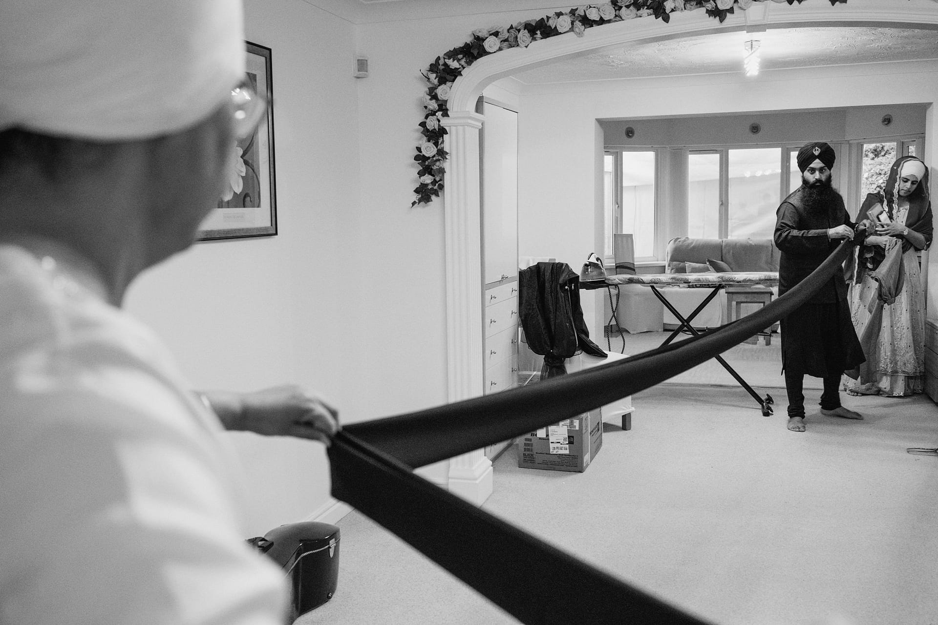 Family preparing large black fabric indoors.