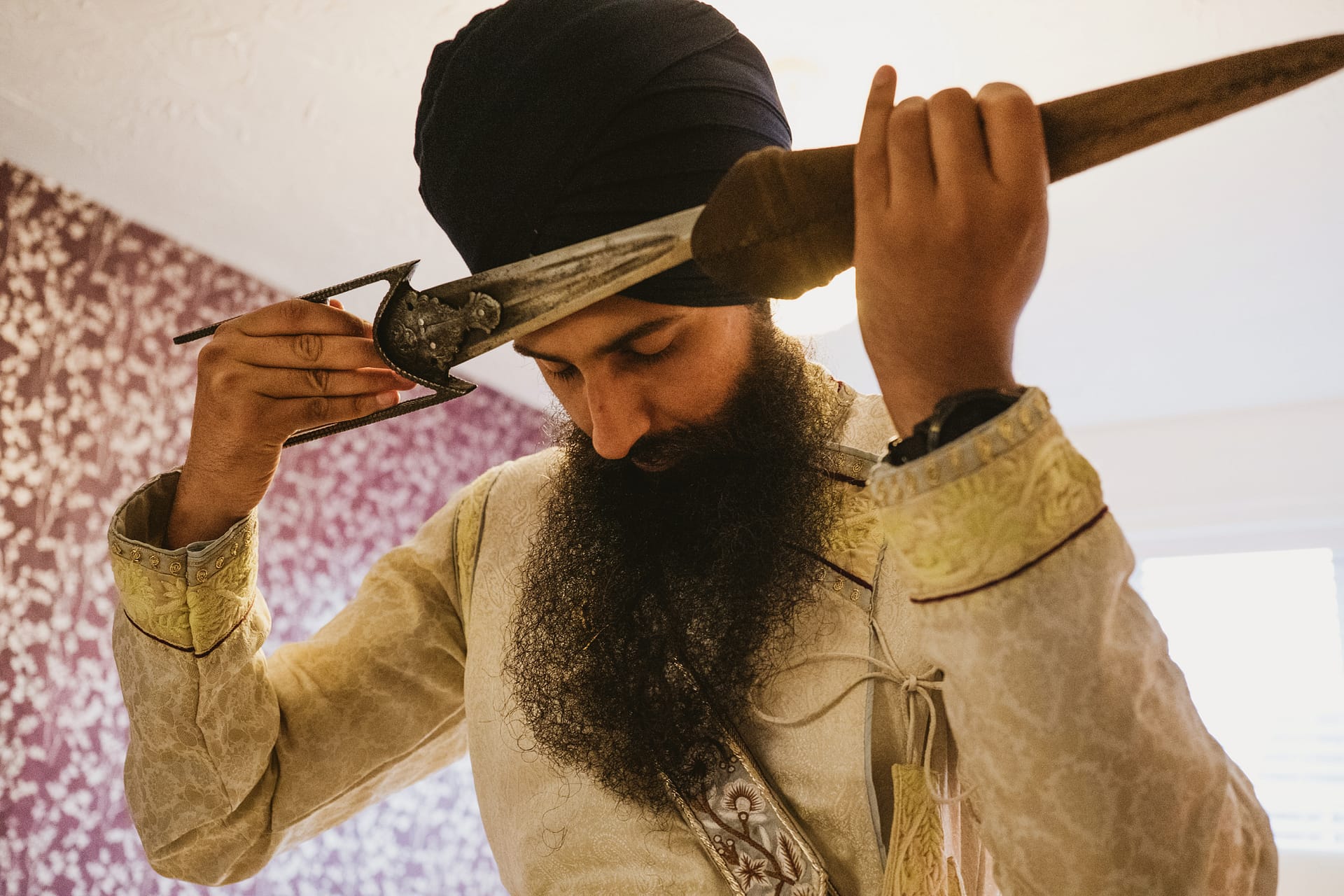 Man in traditional attire holding a sword.