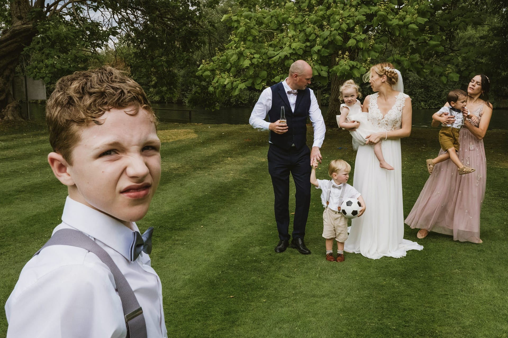 Family at outdoor event with children and football.