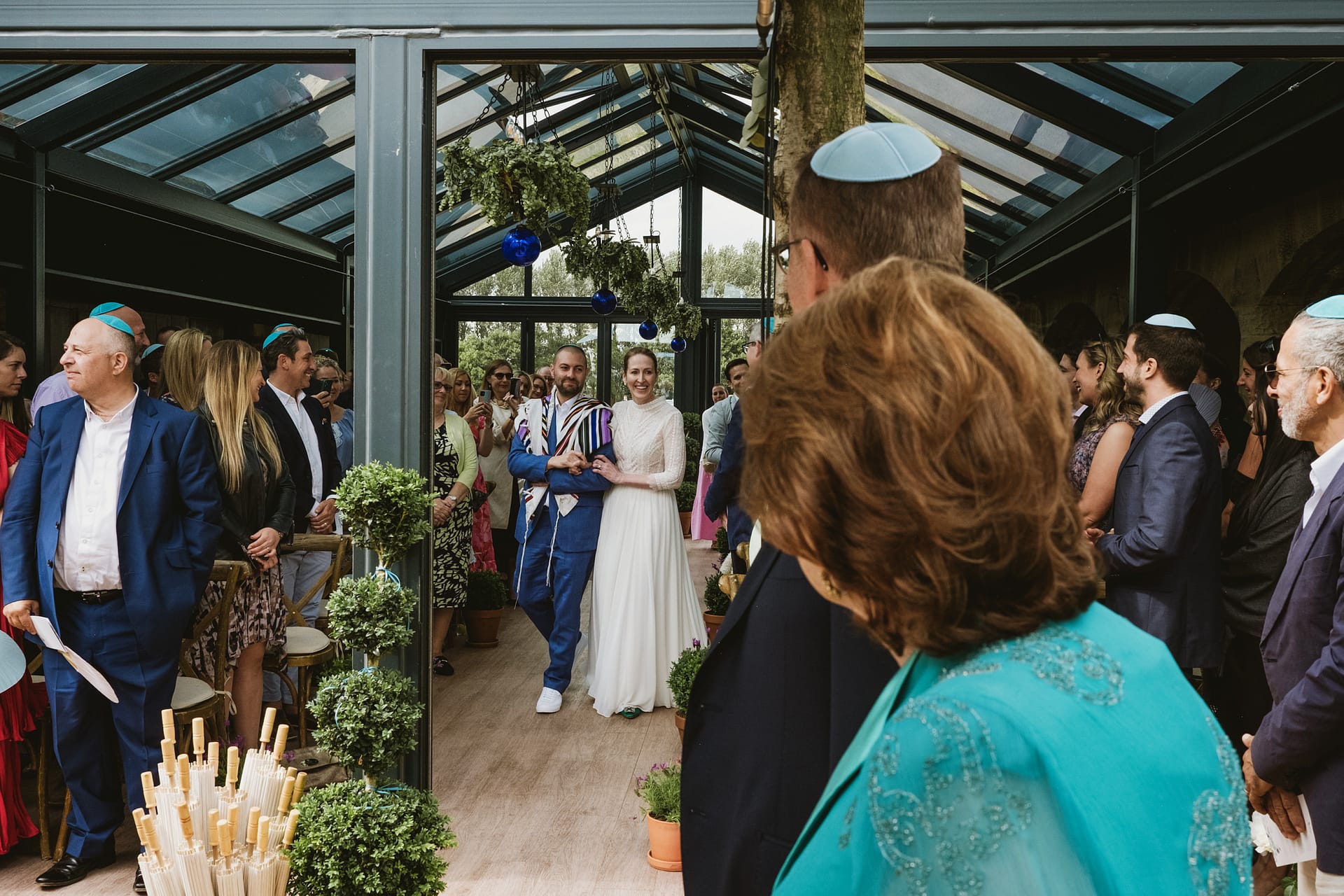 Jewish wedding ceremony with bride and groom walking.