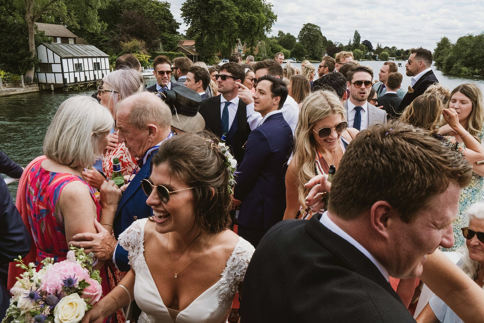Group gathering by the riverside on a sunny day.