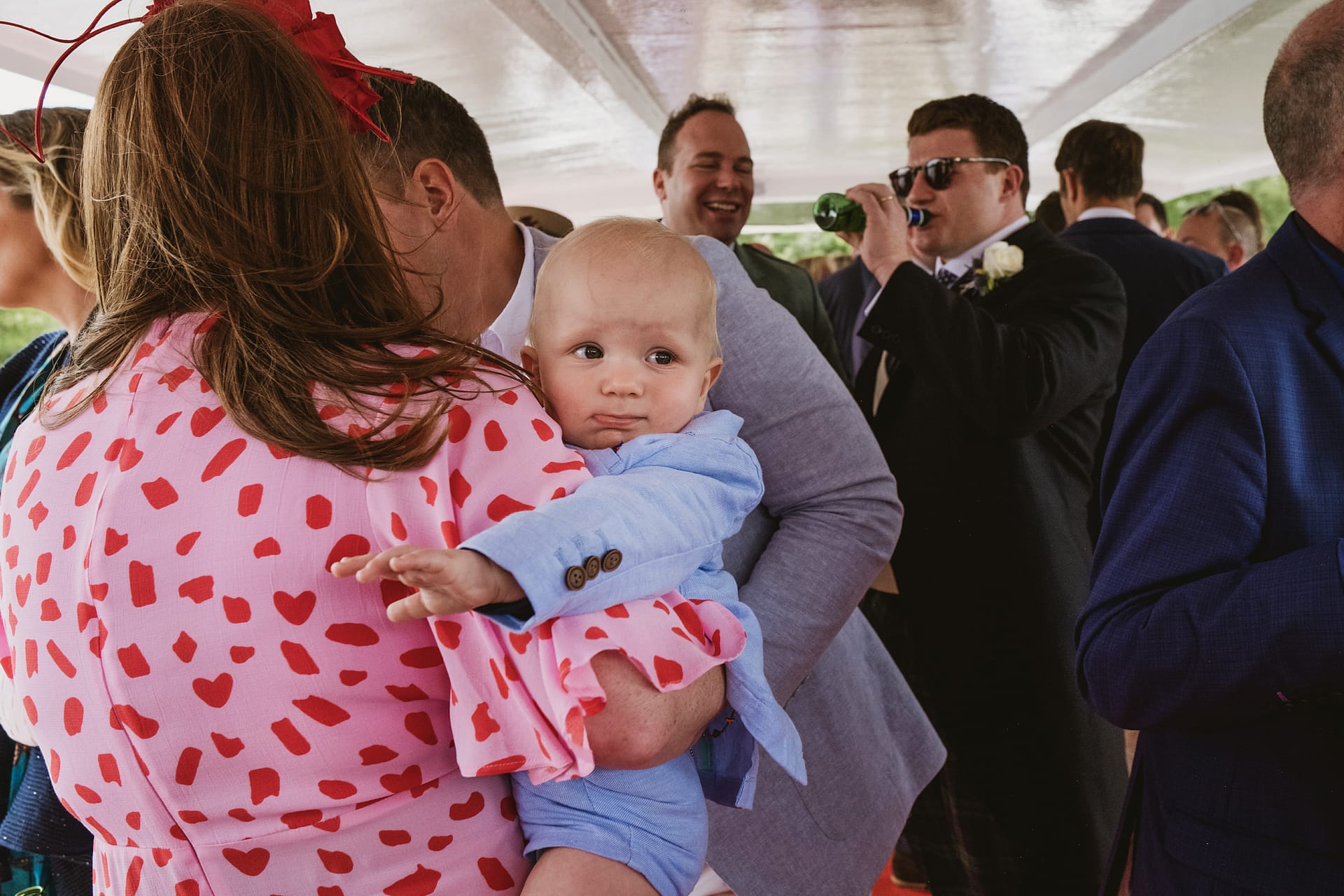 Baby held at lively social event.