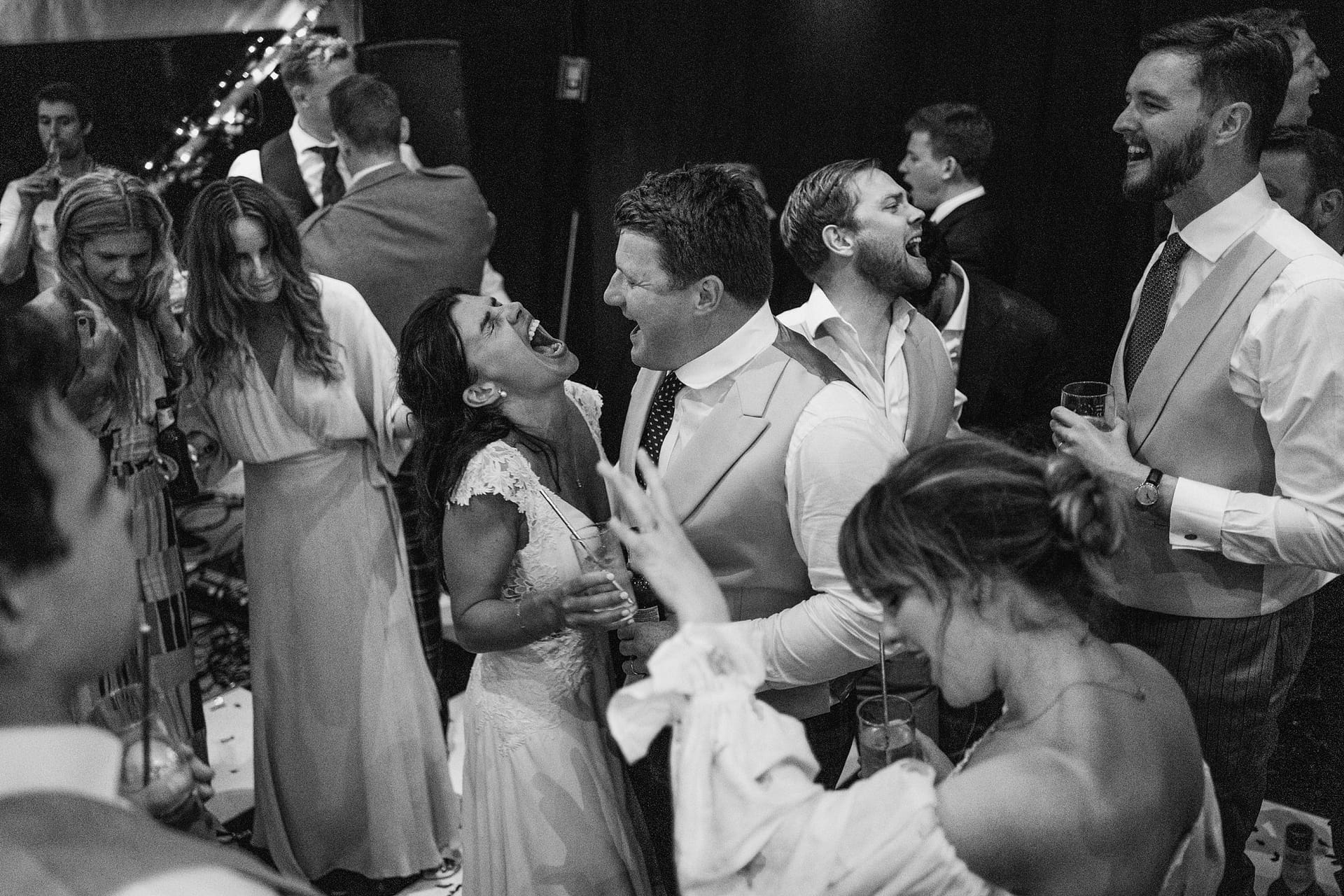 People celebrating and laughing at a wedding party.