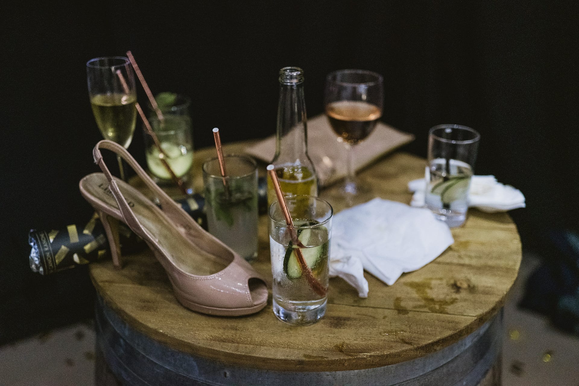 Table with drinks, high heels, and napkins.