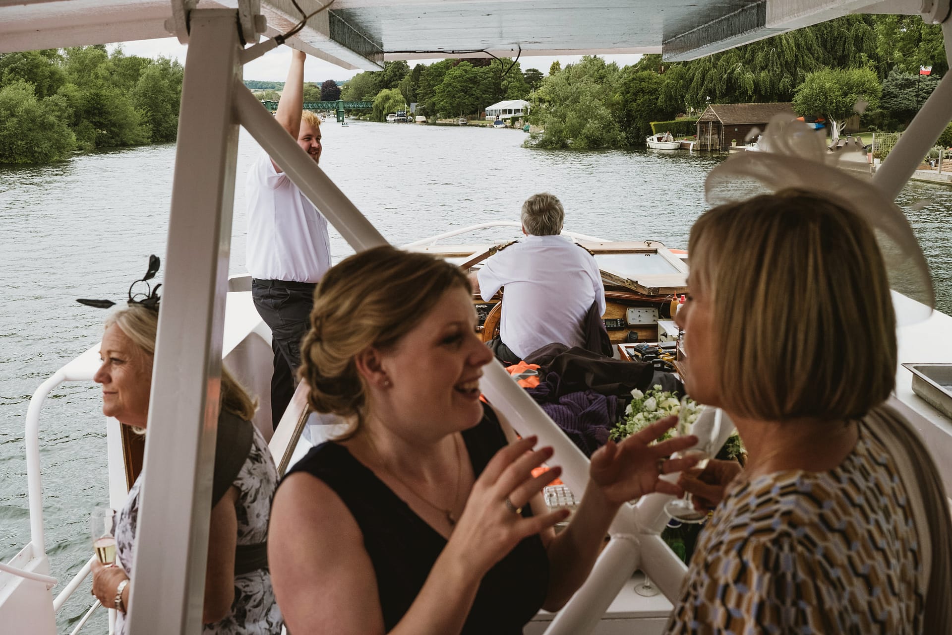 People socialising on a boat by a river.
