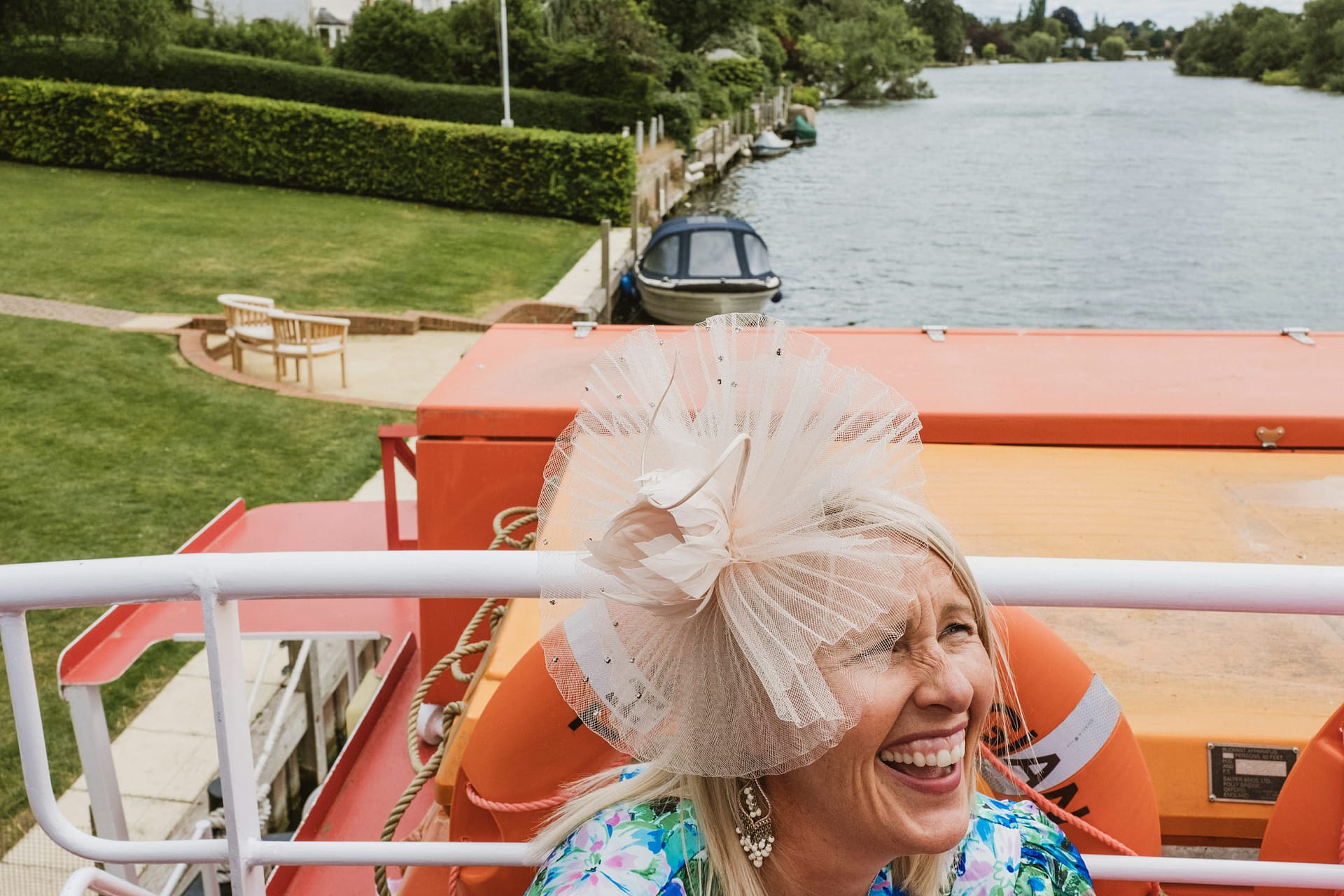 Woman laughing on a boat by the river.