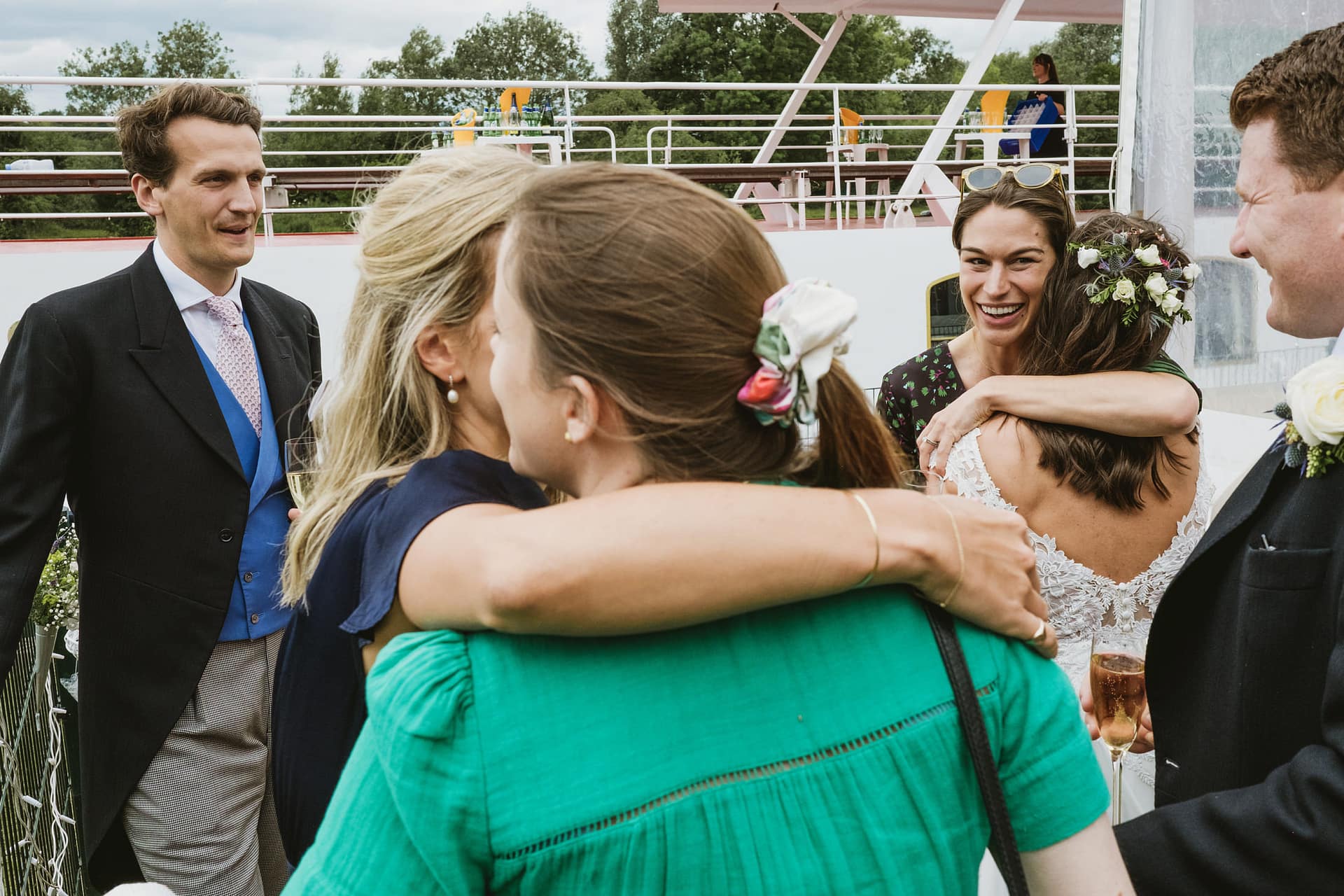 Guests hugging at an outdoor wedding reception.