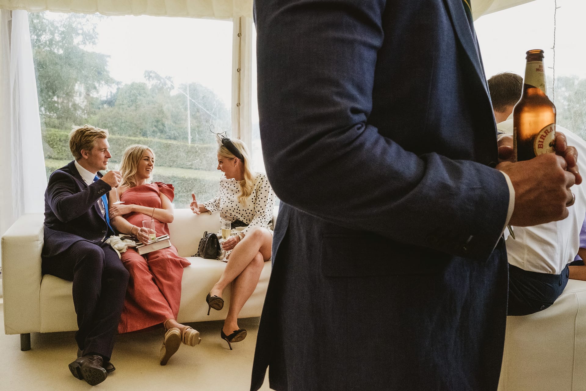 People enjoying drinks while sitting on a couch.