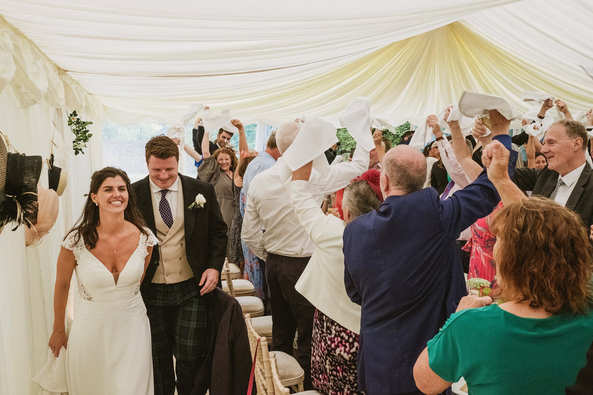 Happy couple walking through joyful wedding guests.