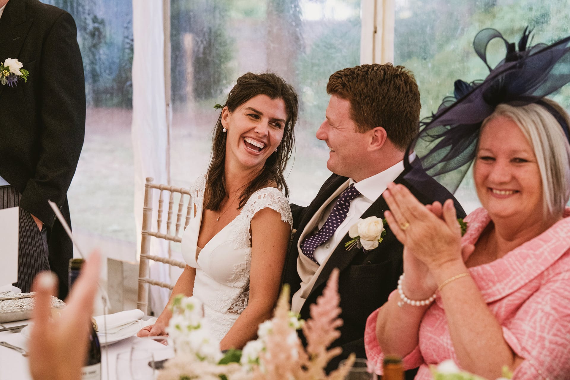 Bride and groom laughing at wedding reception.