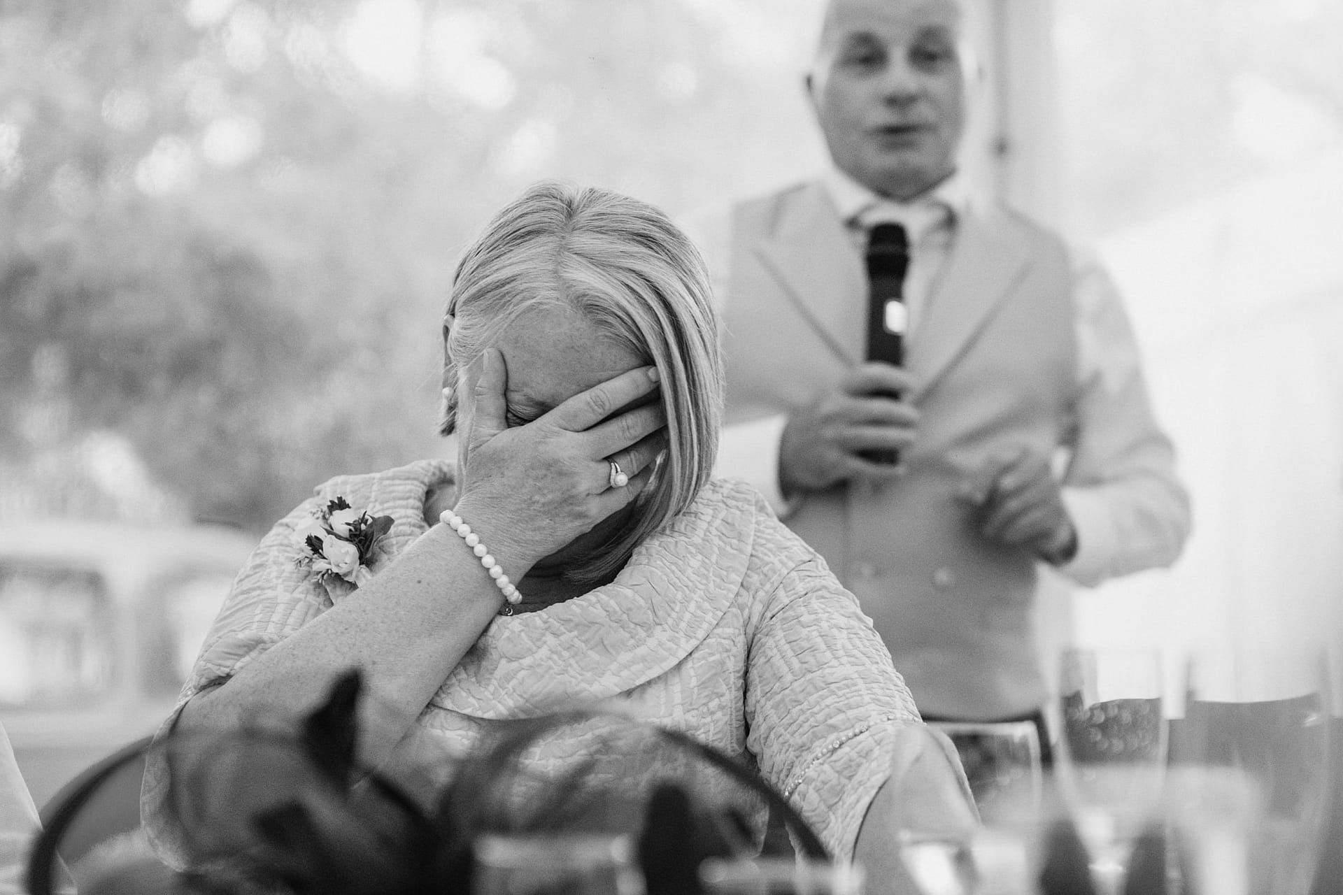 Emotional woman covering face during a speech.