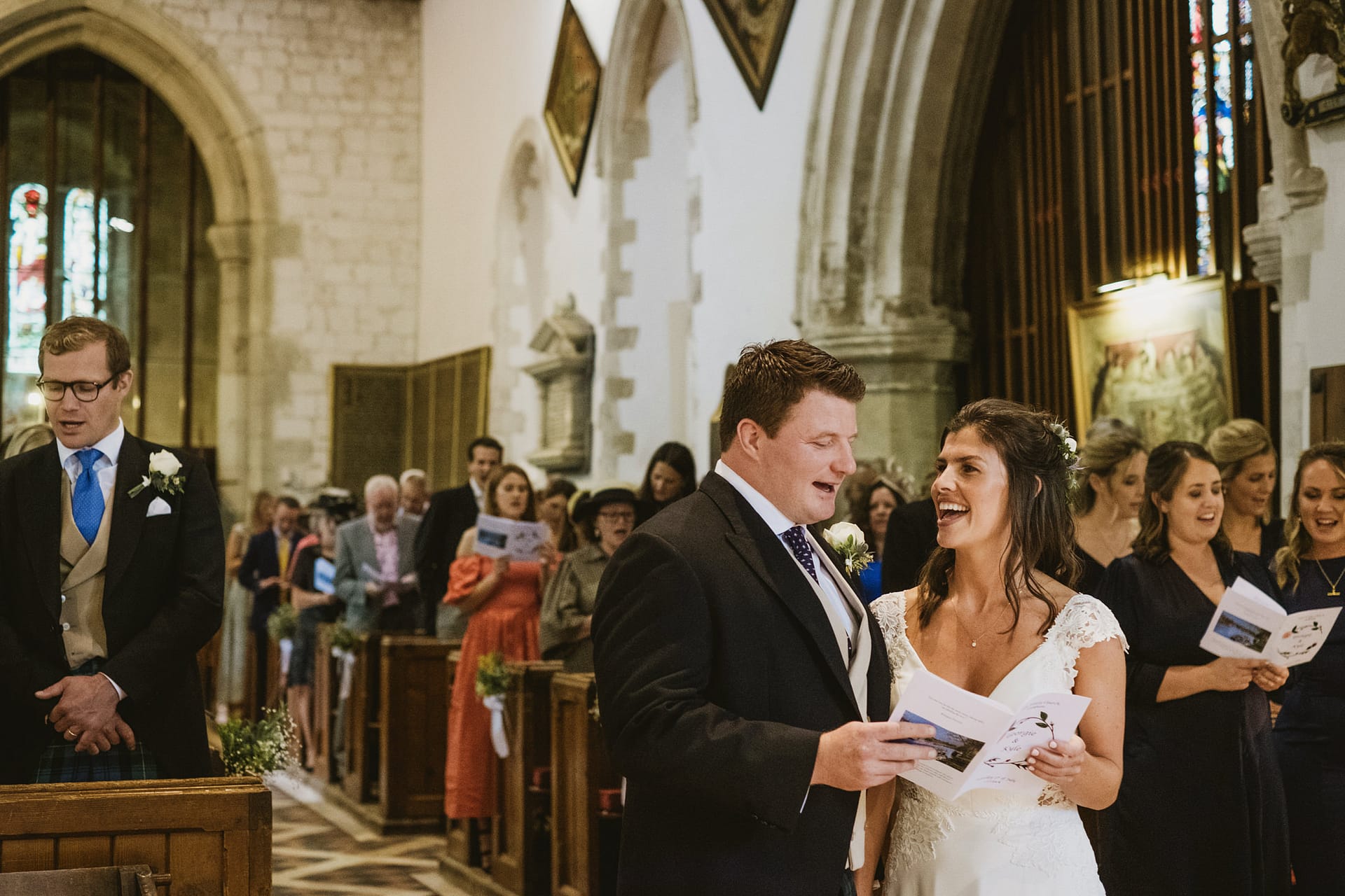 Bride and groom singing in church wedding ceremony.