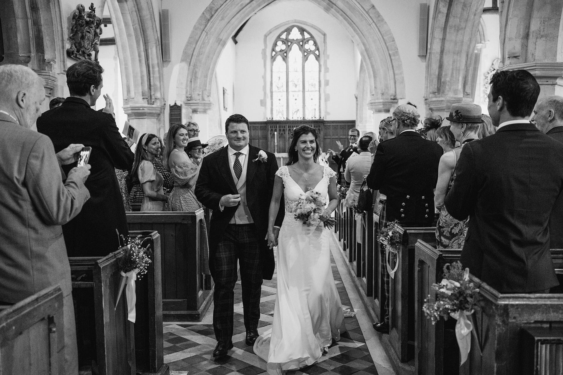 Bride and groom walking down church aisle