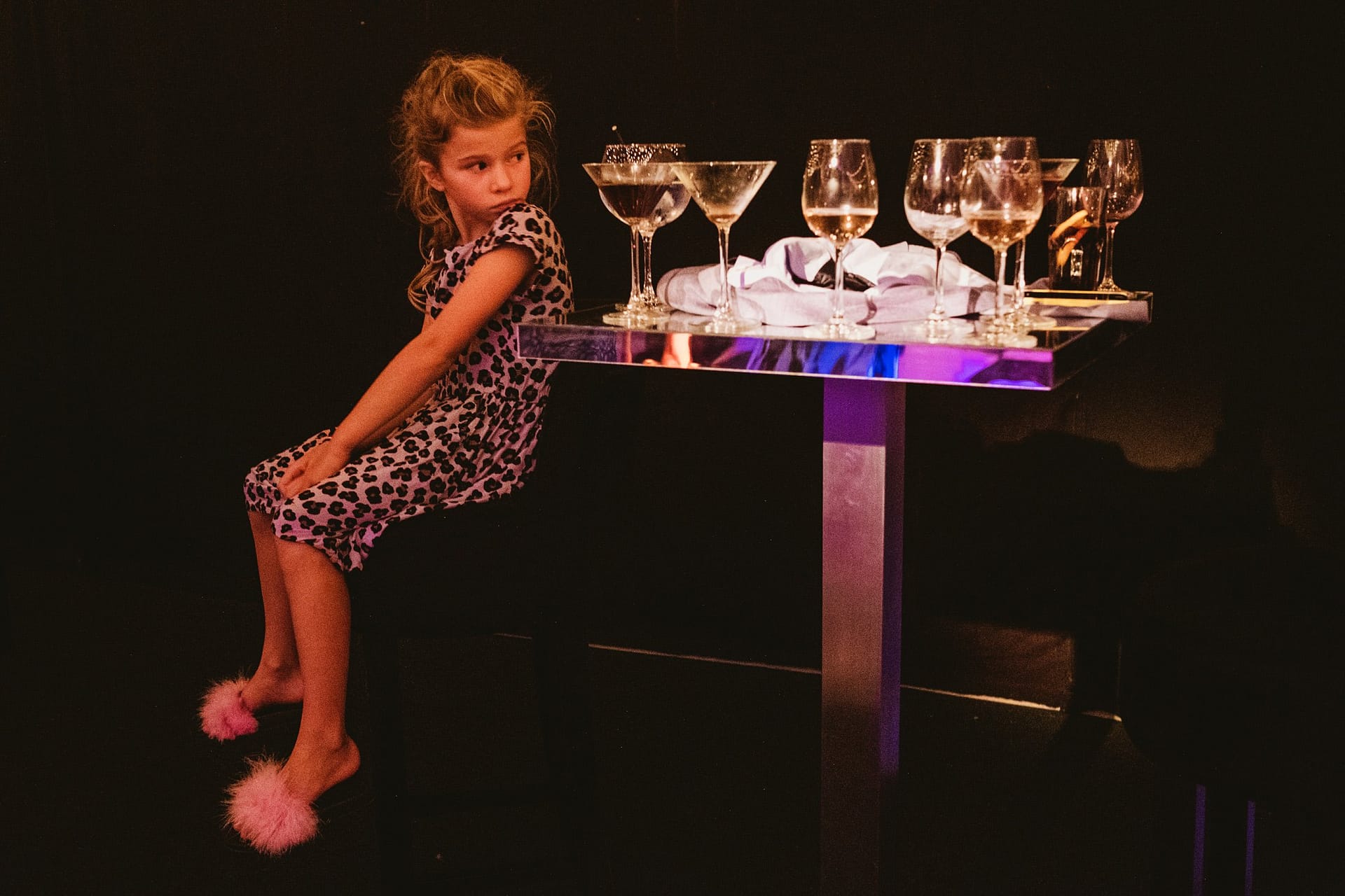 girl with wine glasses next to the dance floor