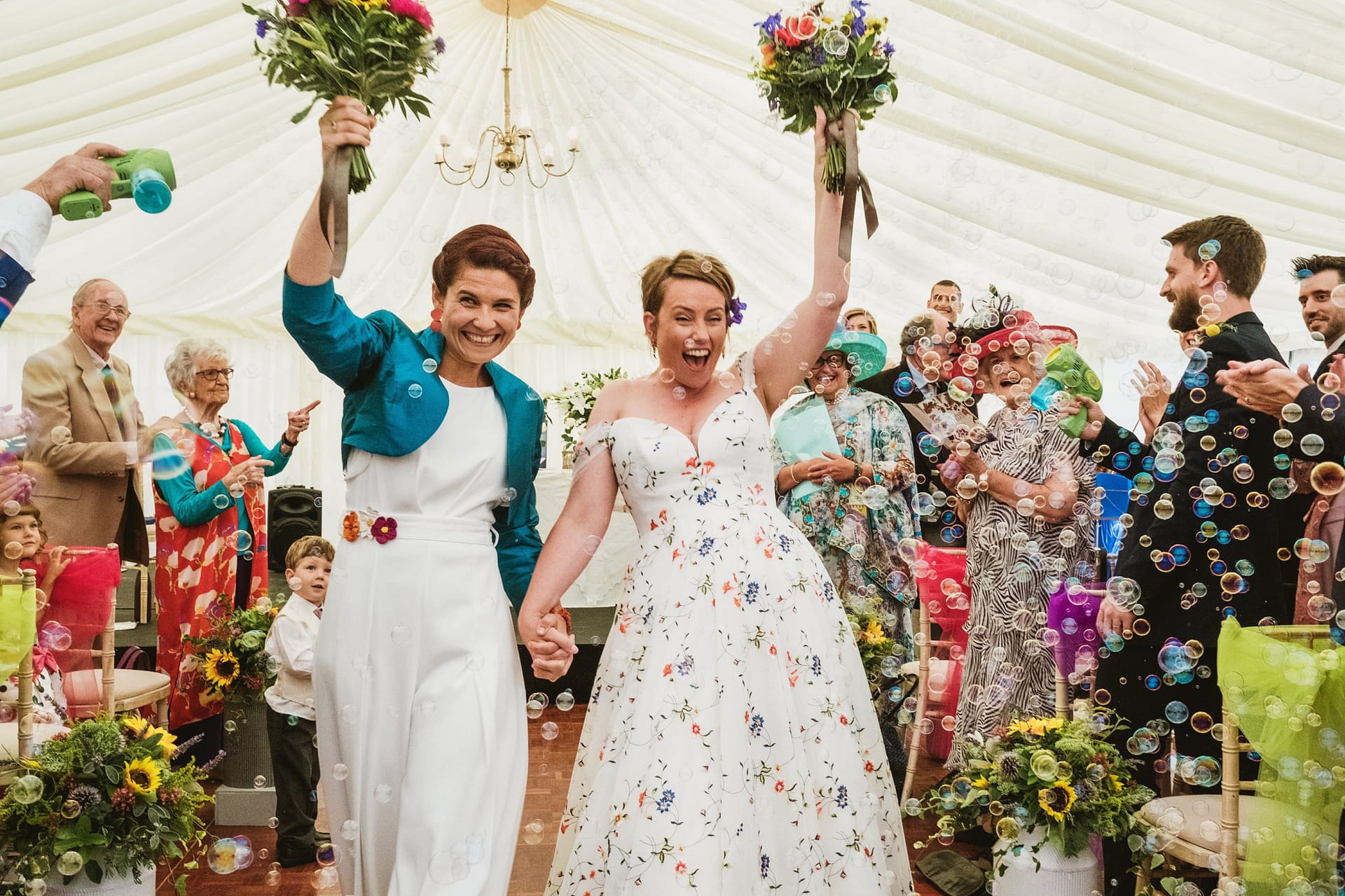 the bride leaving the chelsea physic garden ceremony with guests cheering and bubbles