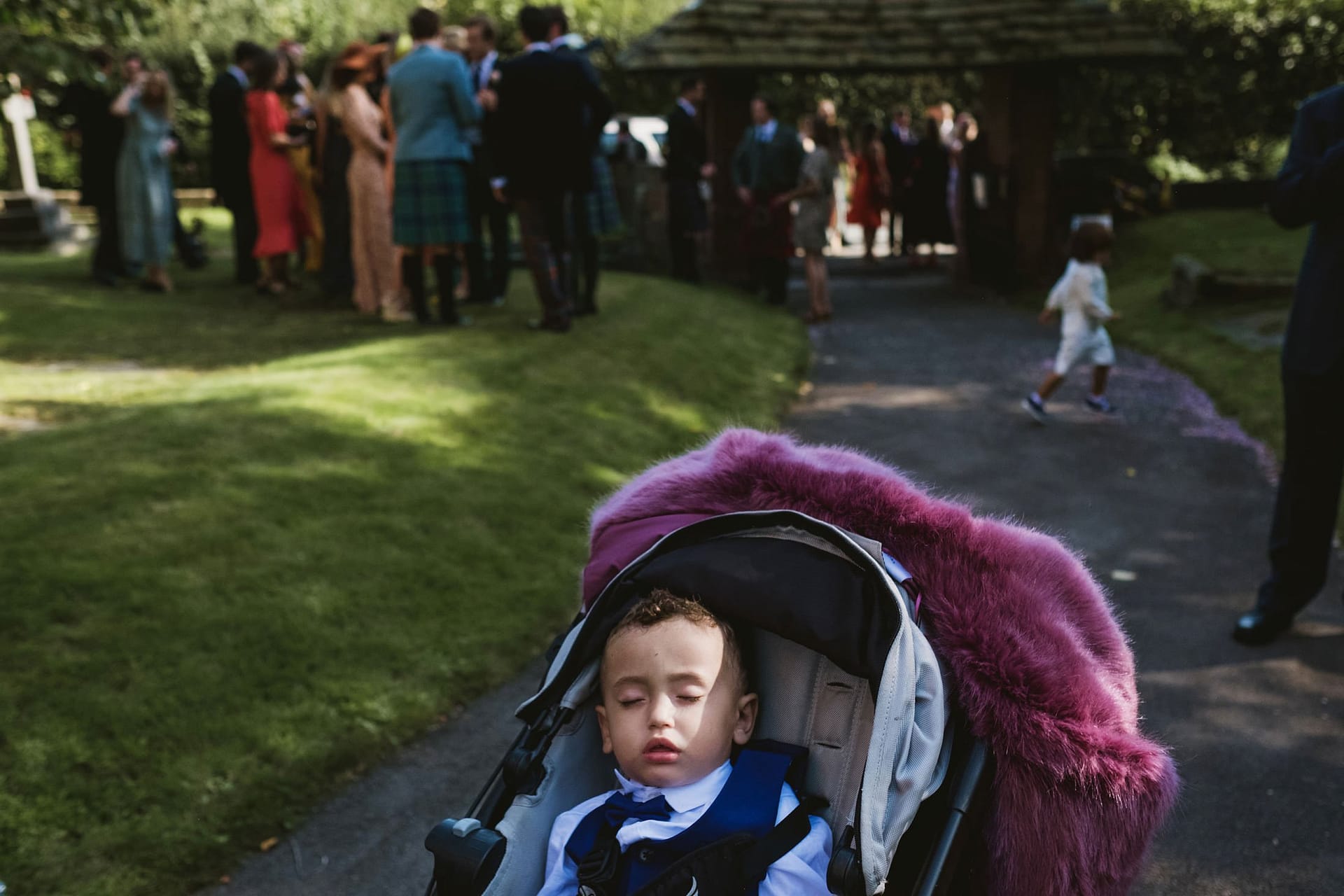 little boy sleeping in pram at church in Cheshire