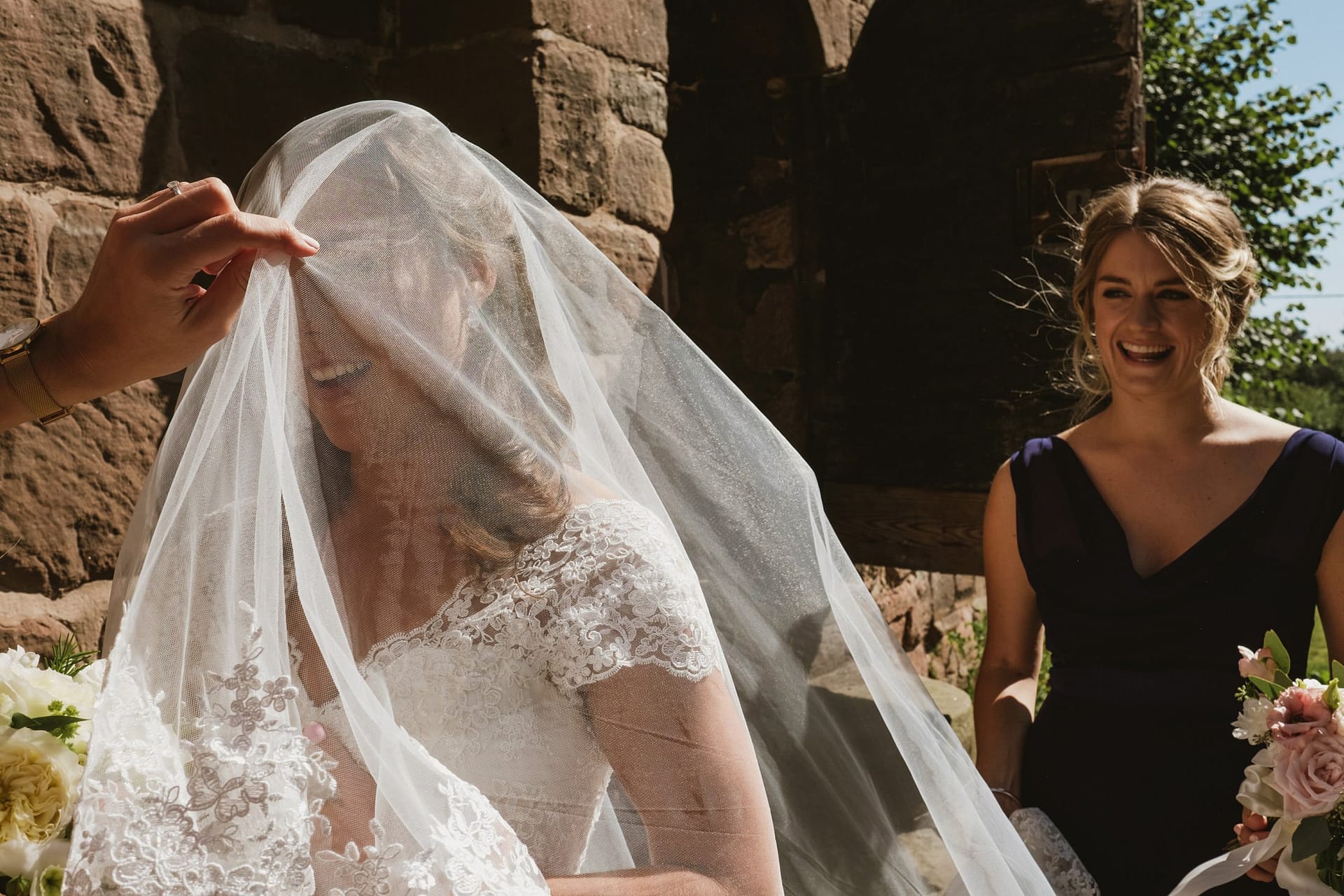 bride putting her veil on at the church