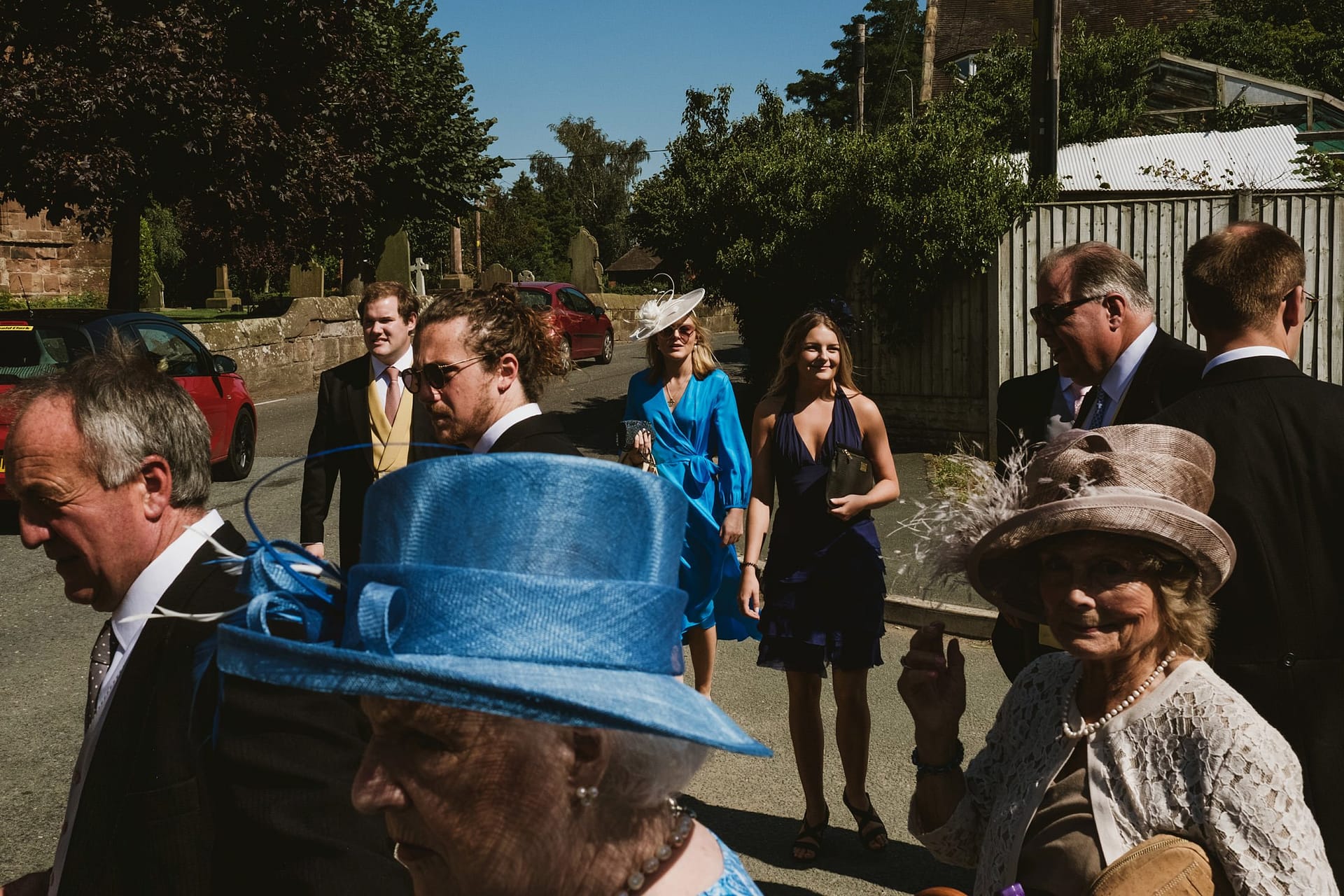 wedding guests walking to the church from the pub in Cheshire.