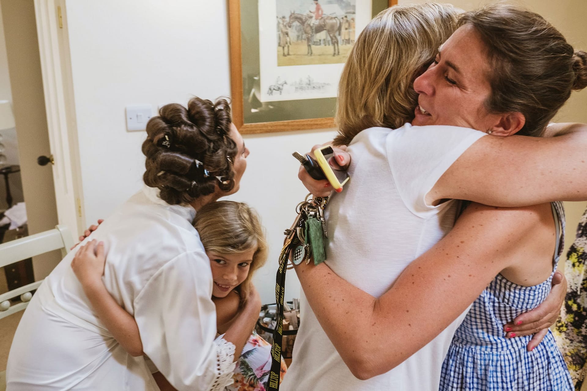bride hugging flower girl and brides mum hugging parent