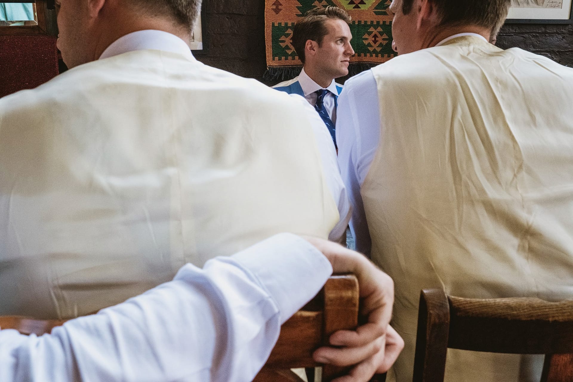 groom framed between two other people