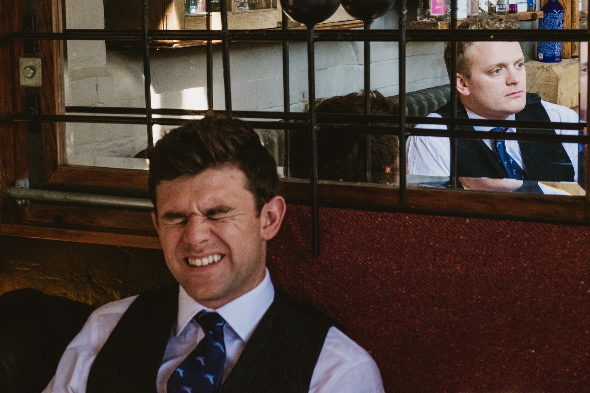 groomsmen, one laughing and one more serious