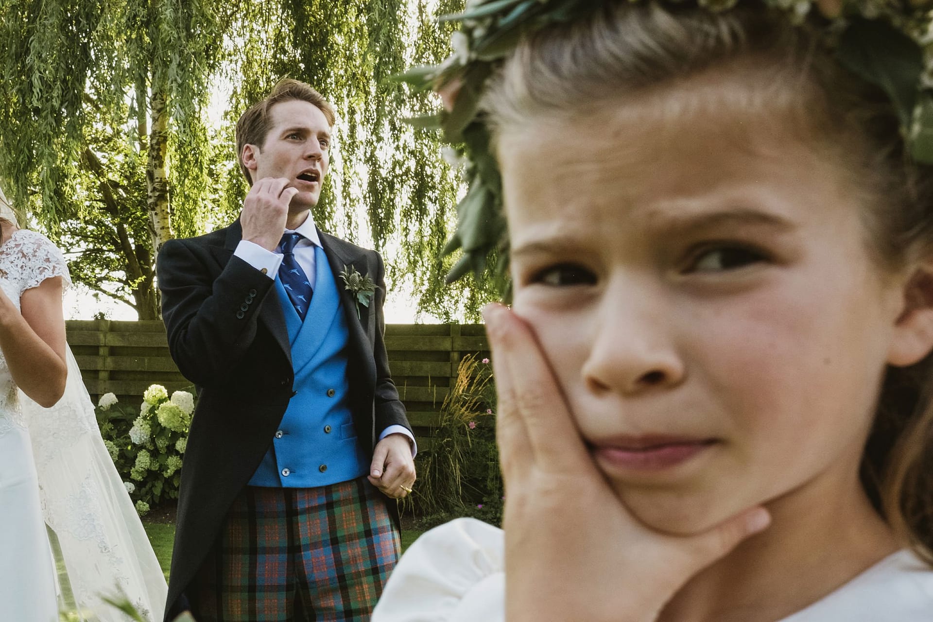 flower girl and groom both with hands to face