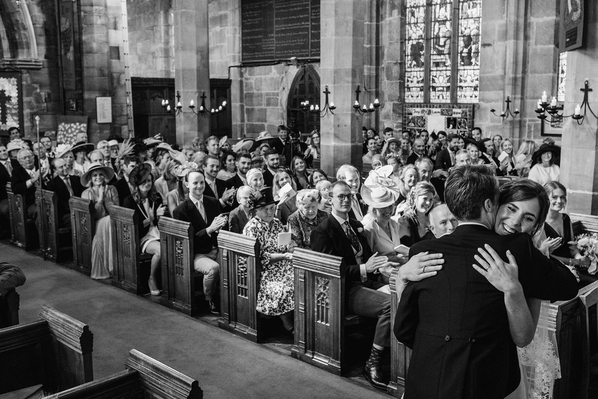 bride and groom during the ceremony, hugging after the first kiss