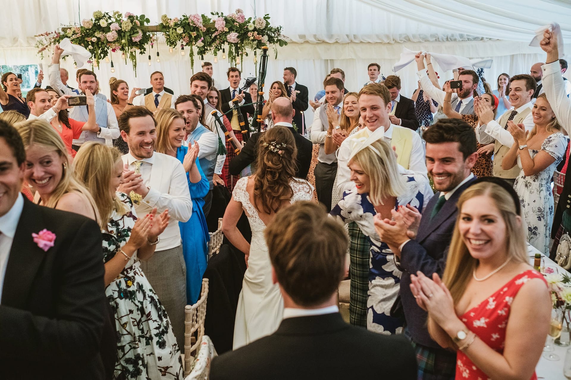 bride and groom wedding entrance, wedding guests all cheering