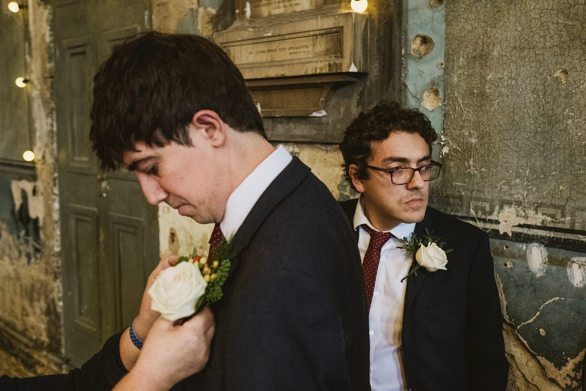 groomsmen putting on their button holes at asylum chape