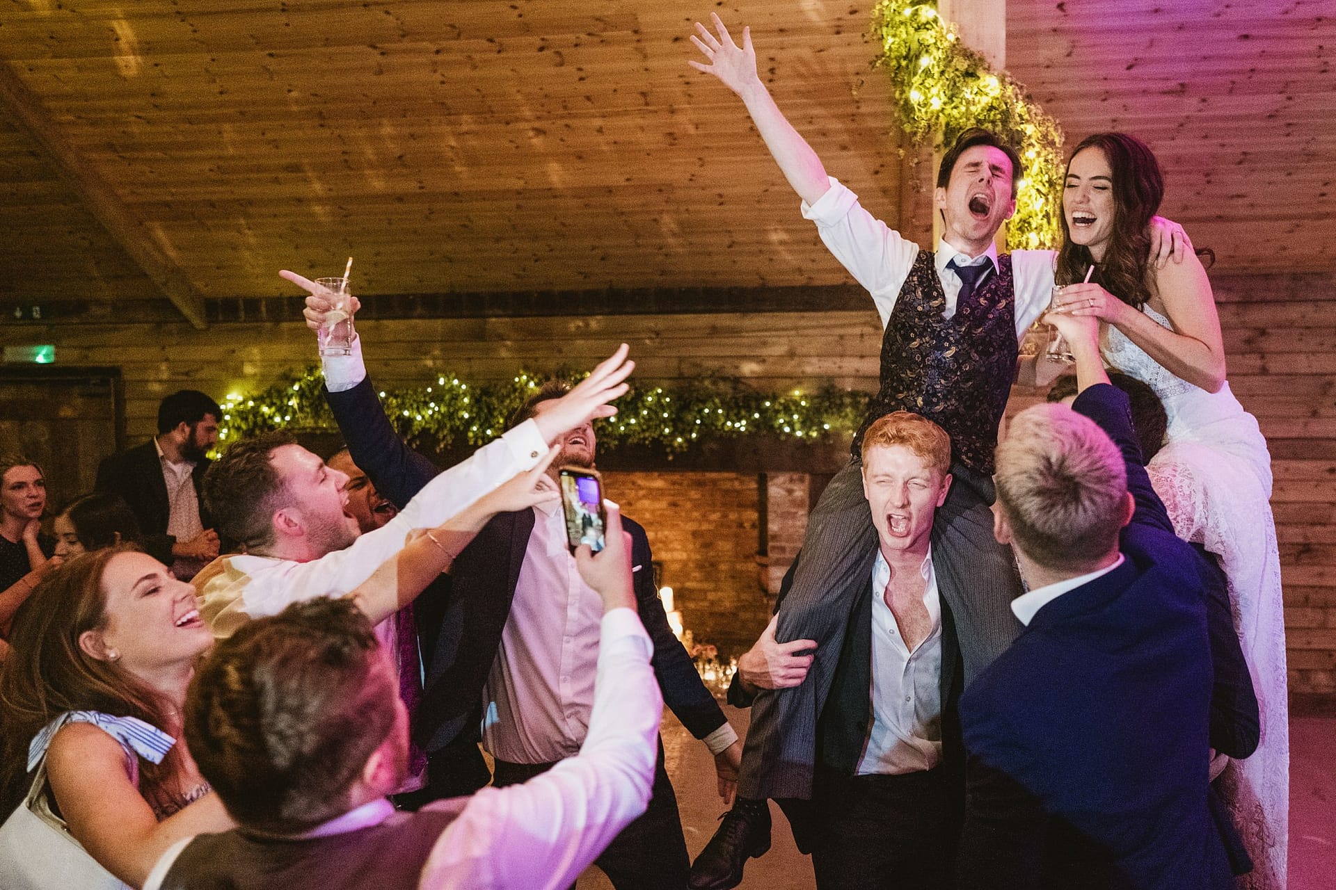 bride, groom on wedding guests shoulders at high billinghurst farm