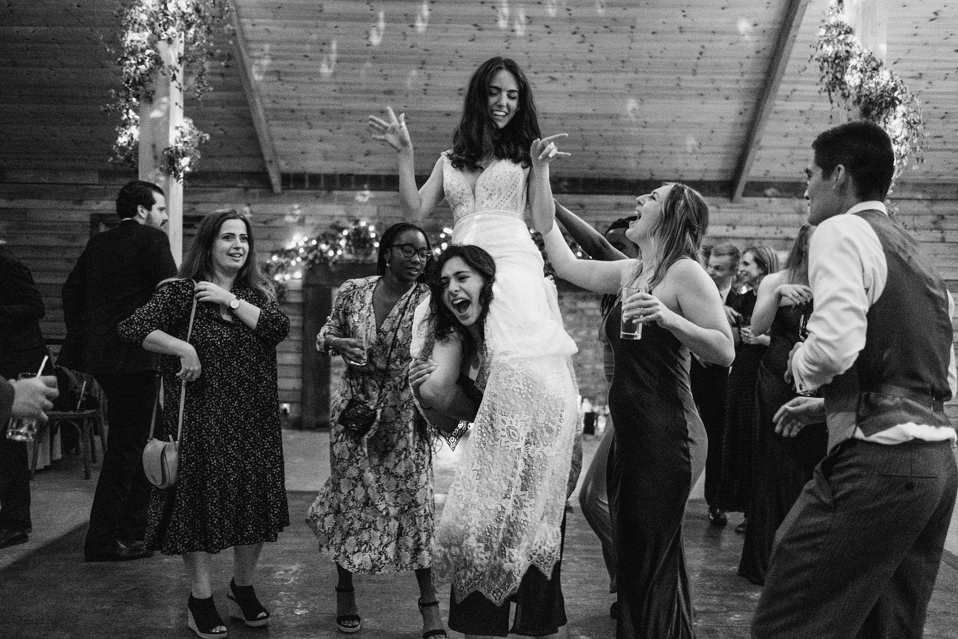 bride on wedding guests shoulders at high billinghurst farm