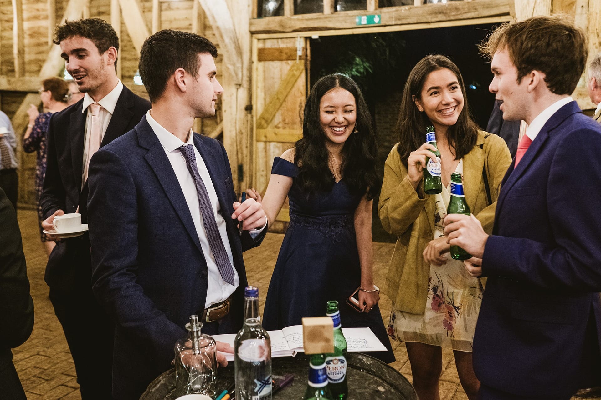 wedding reception guests drinking and laughing at high billinghurst farm in surrey