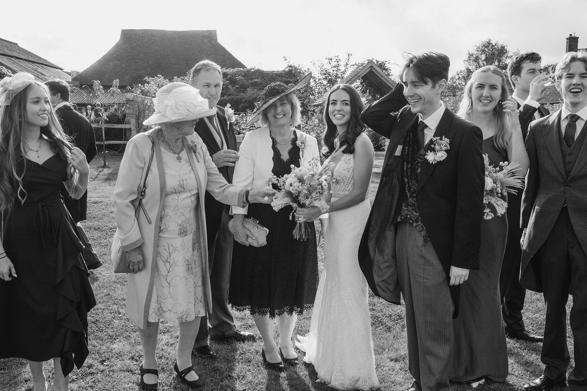 bride, groom and wedding guests all laughing at high billinghurst farm
